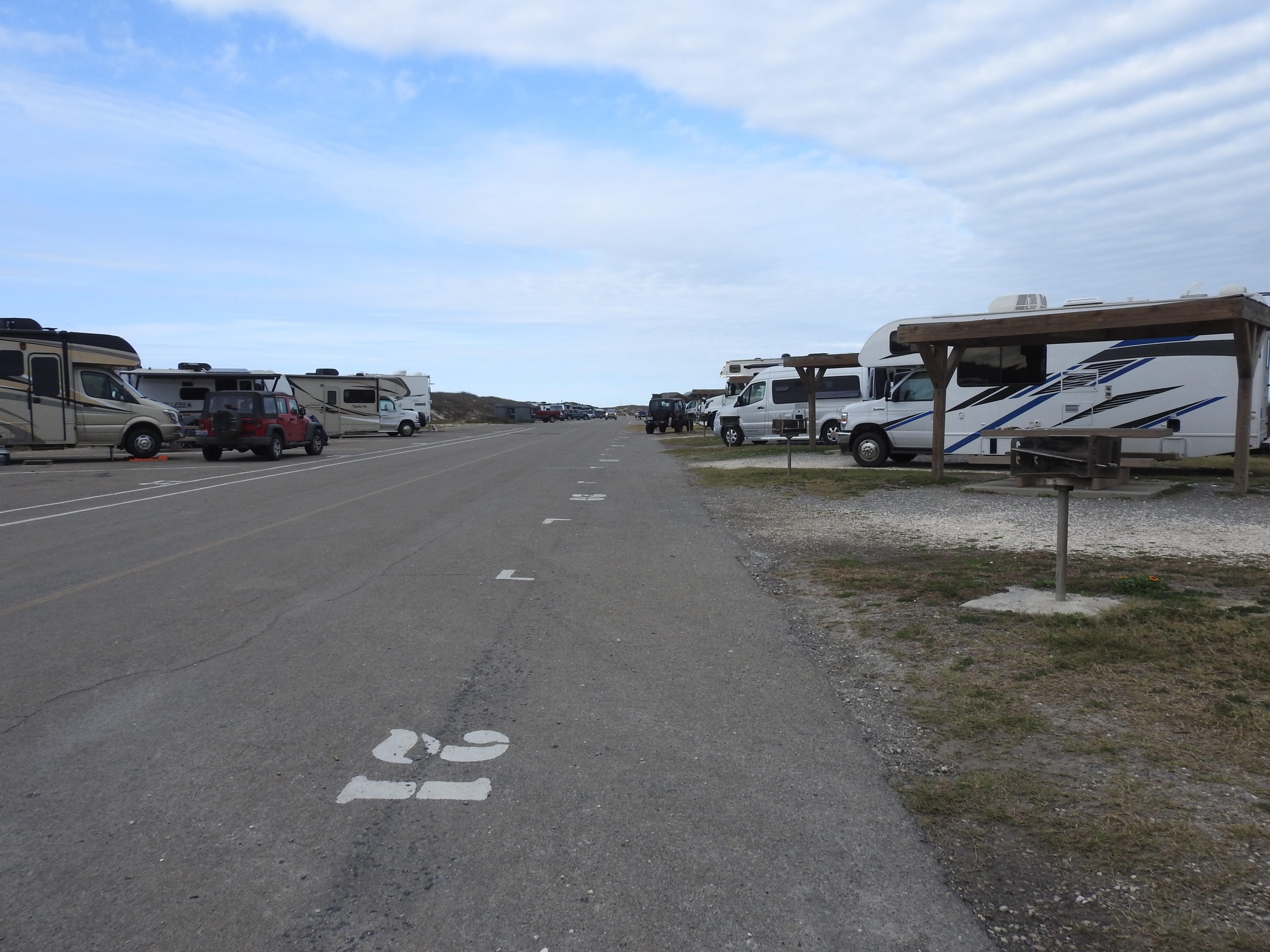 A view down the center road of Malaquite Campgound, paved sites on right and gravel sites on left