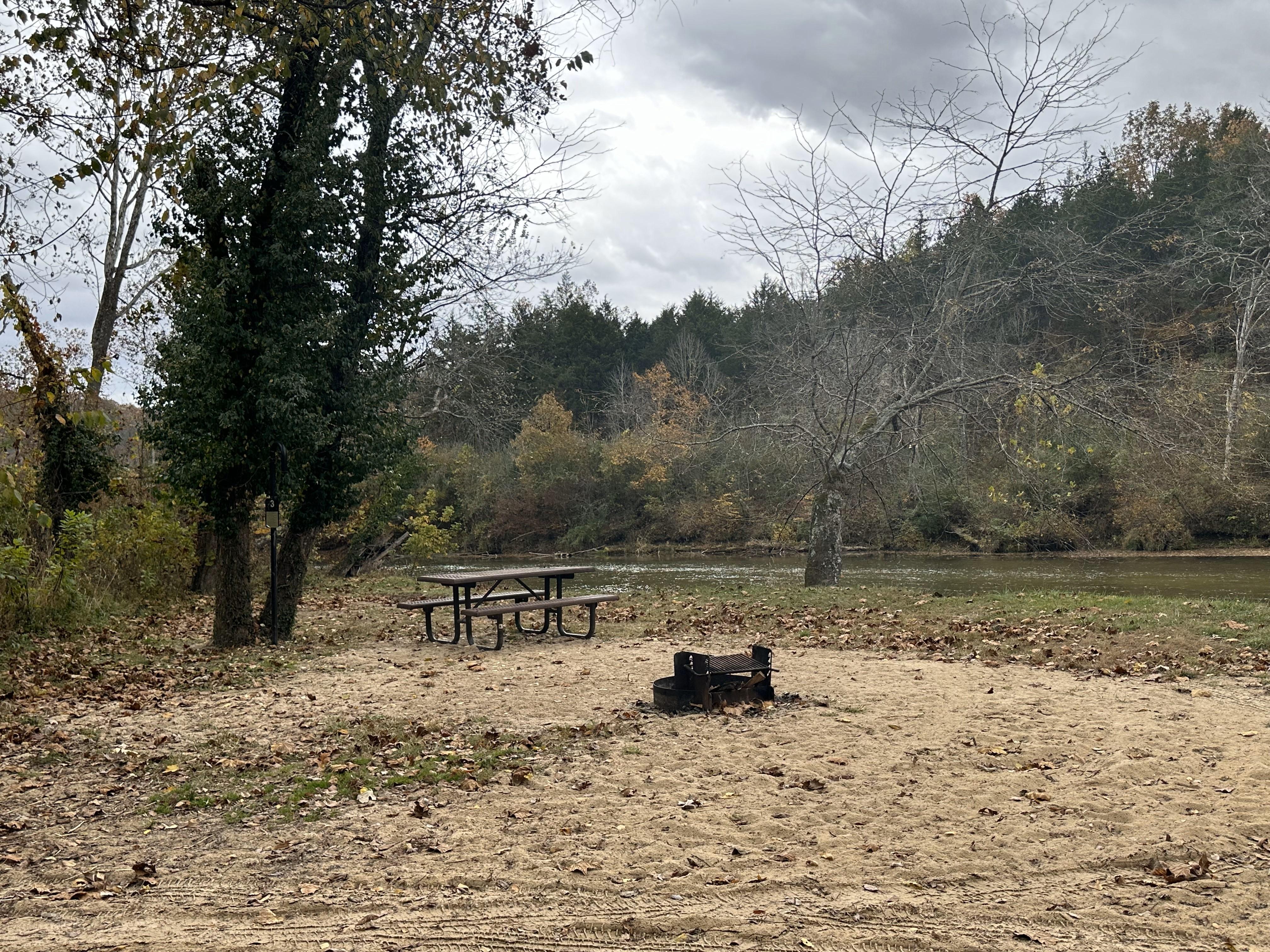 A sandy campsite with an open view of the river.