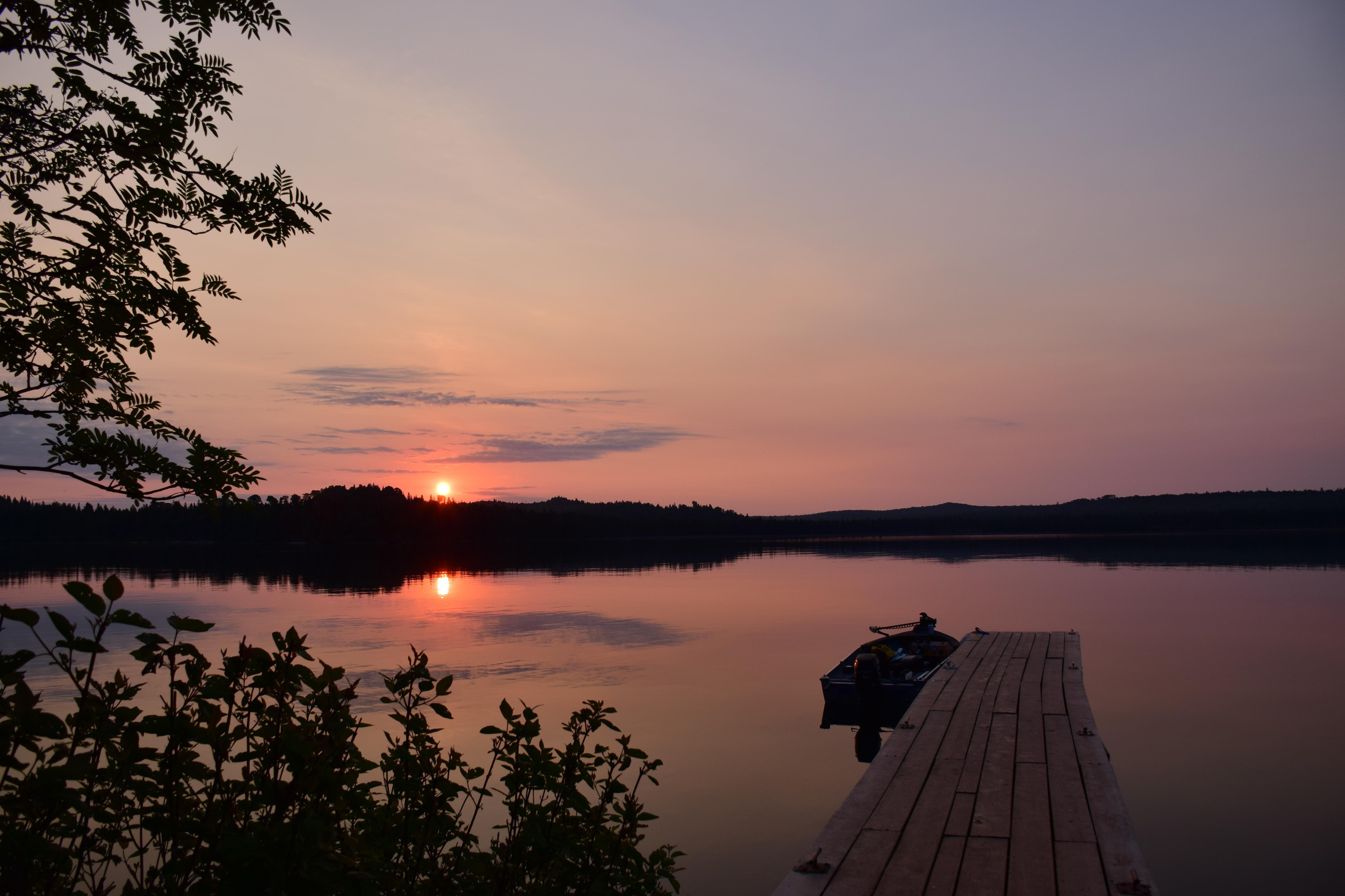 Dock at sunset overlooking Washington Harbor with a motorboat tied off to the dock.