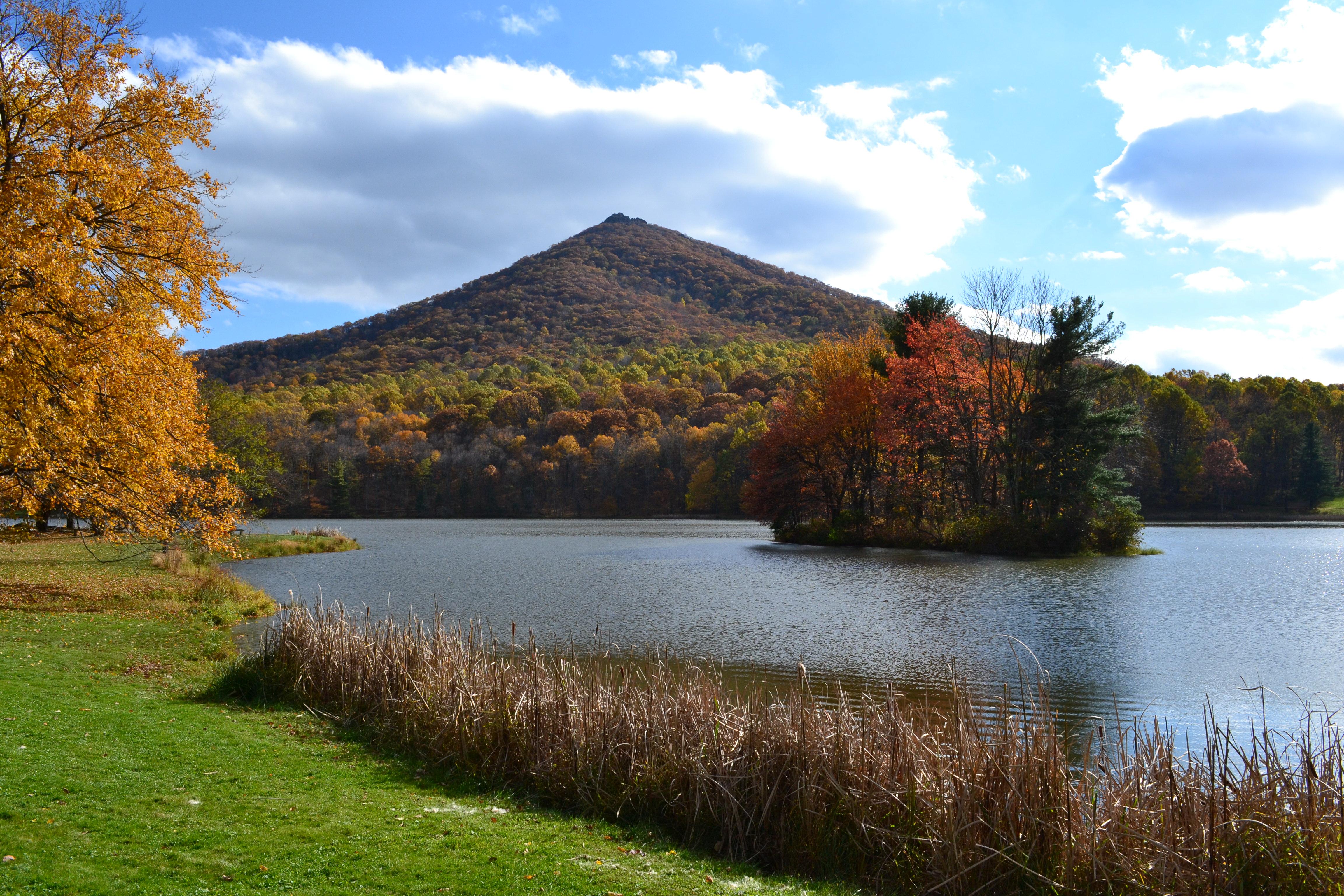A pointed, conical mountain rises above a lake
