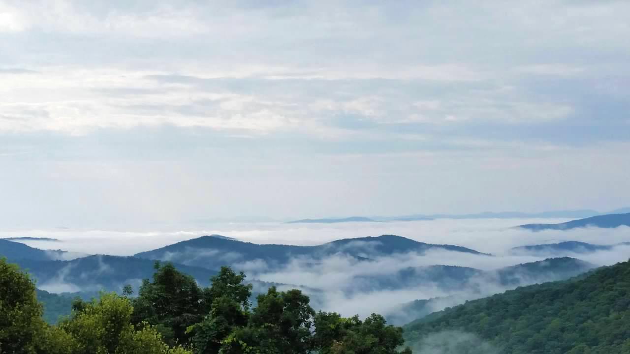 Fog clouds hug the valleys while mountain tops rise above the sea of white
