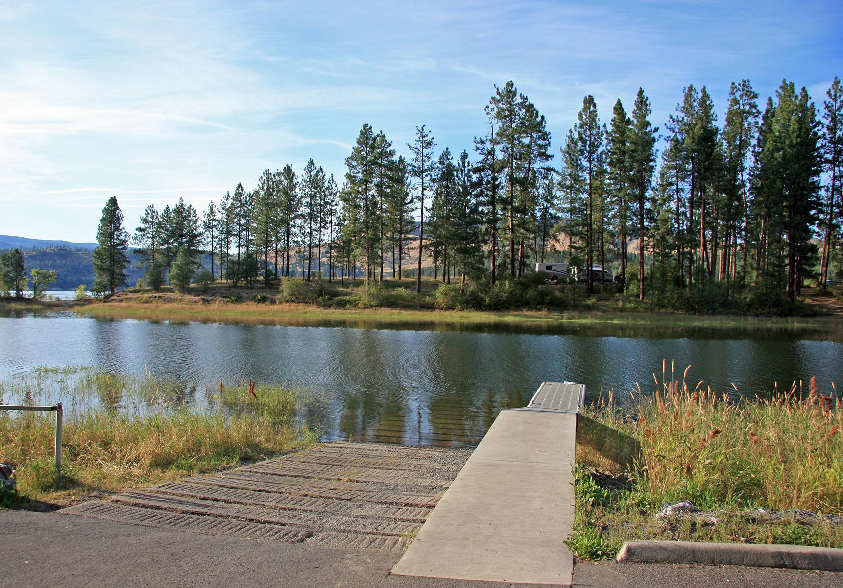 a cement ramp and metal dock declining into the lake water