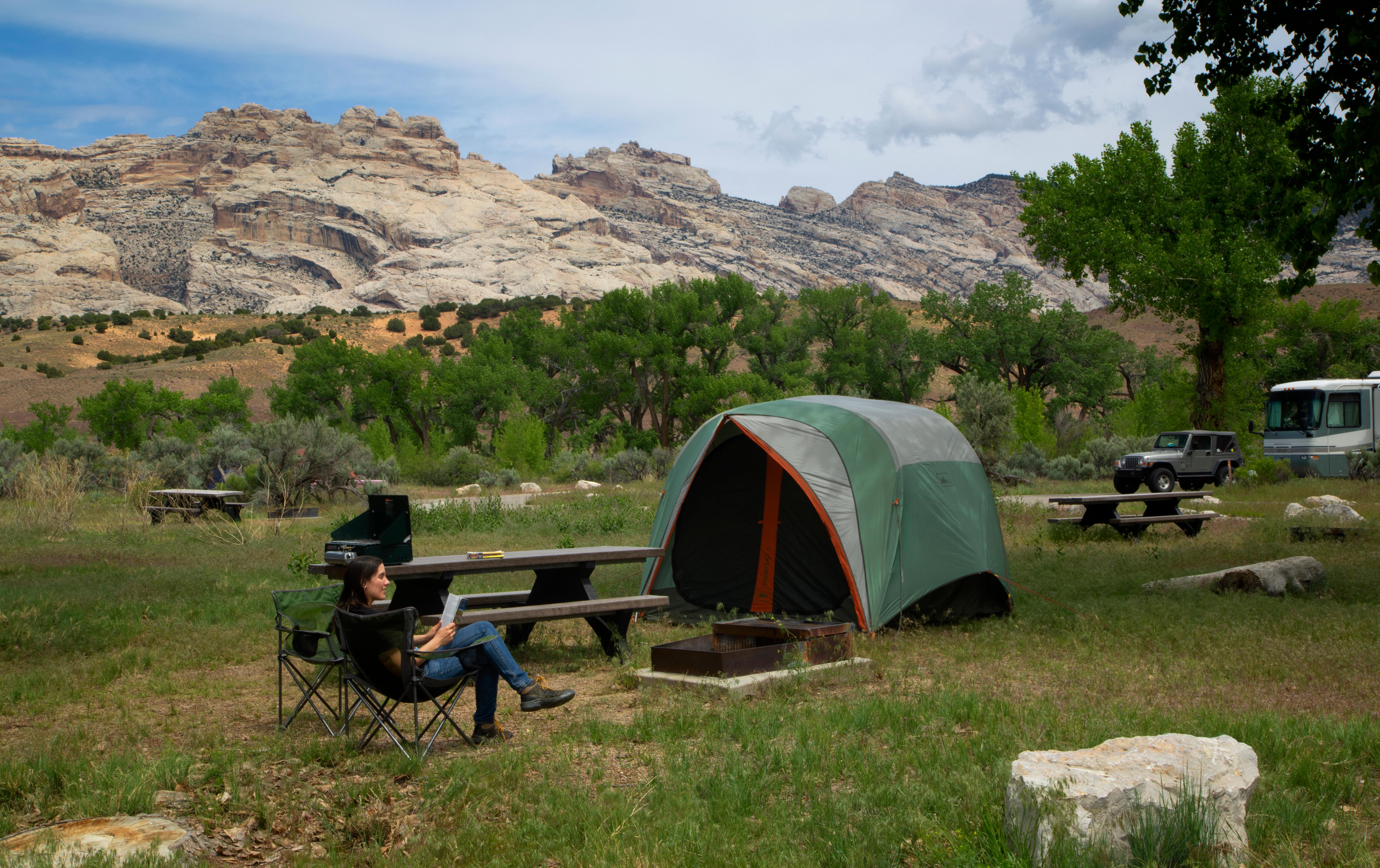 A woman sitting in a chair in front of a tent