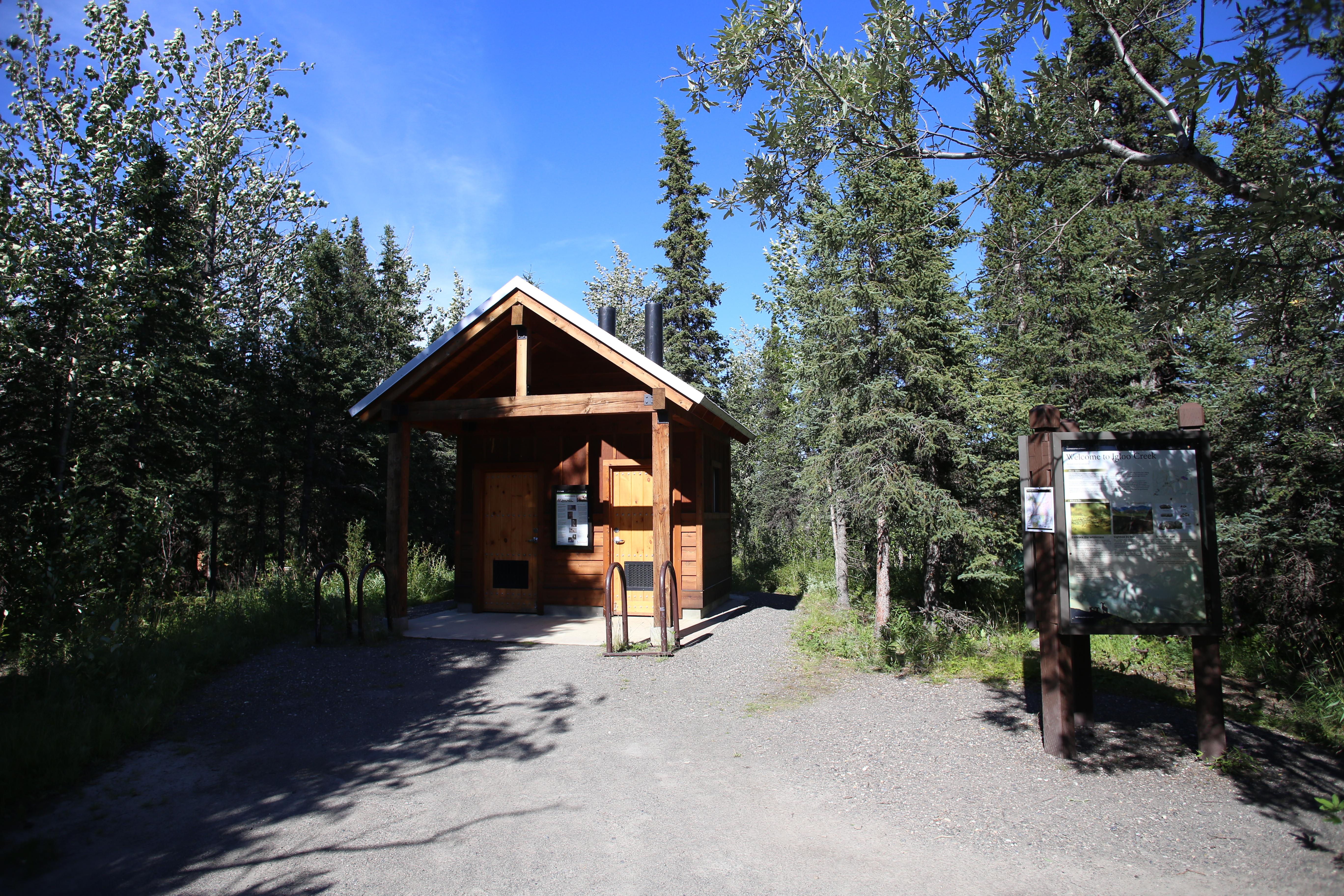 wooden building with two doors in a forest