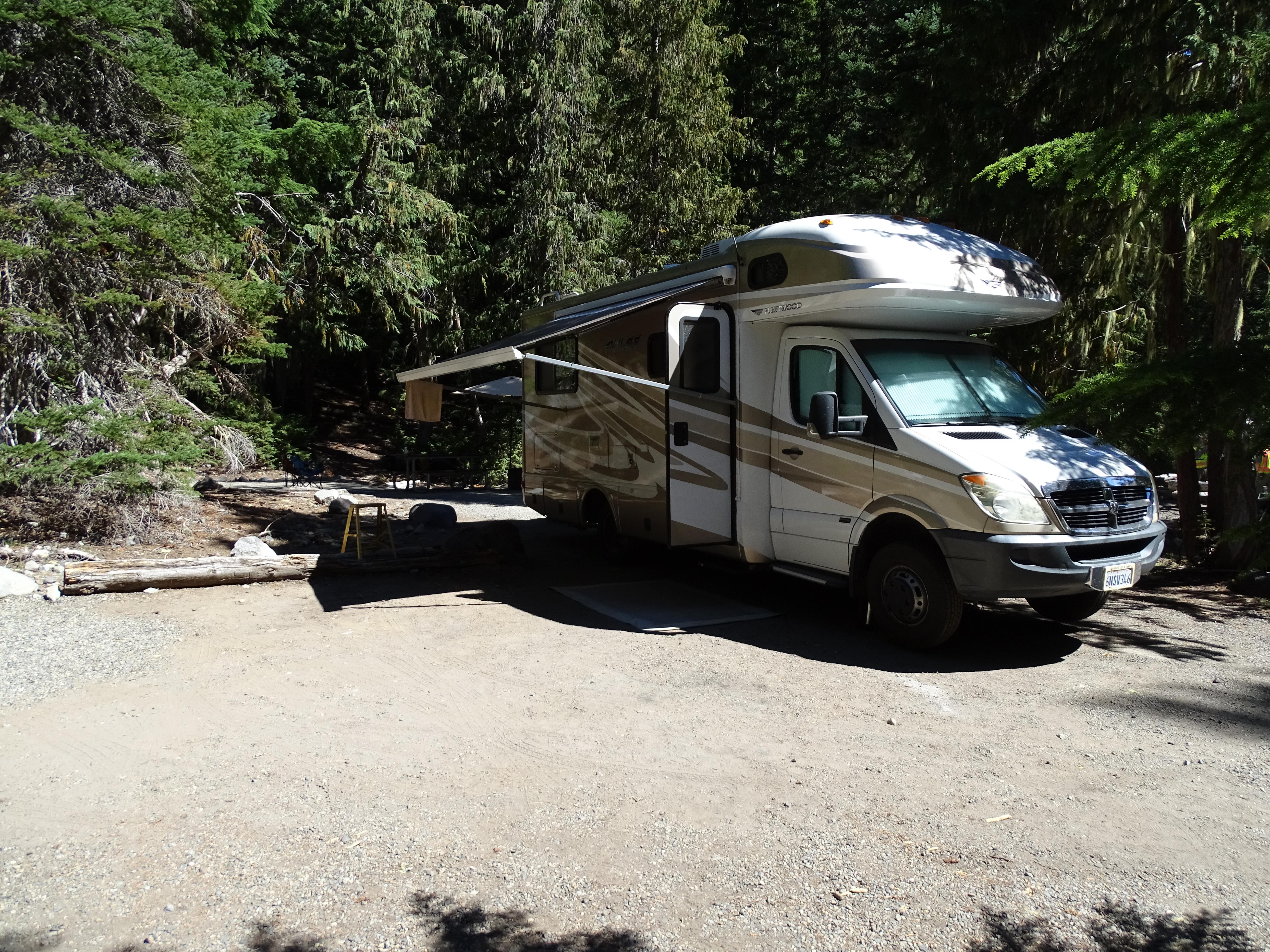 A large white RV in a campsite.
