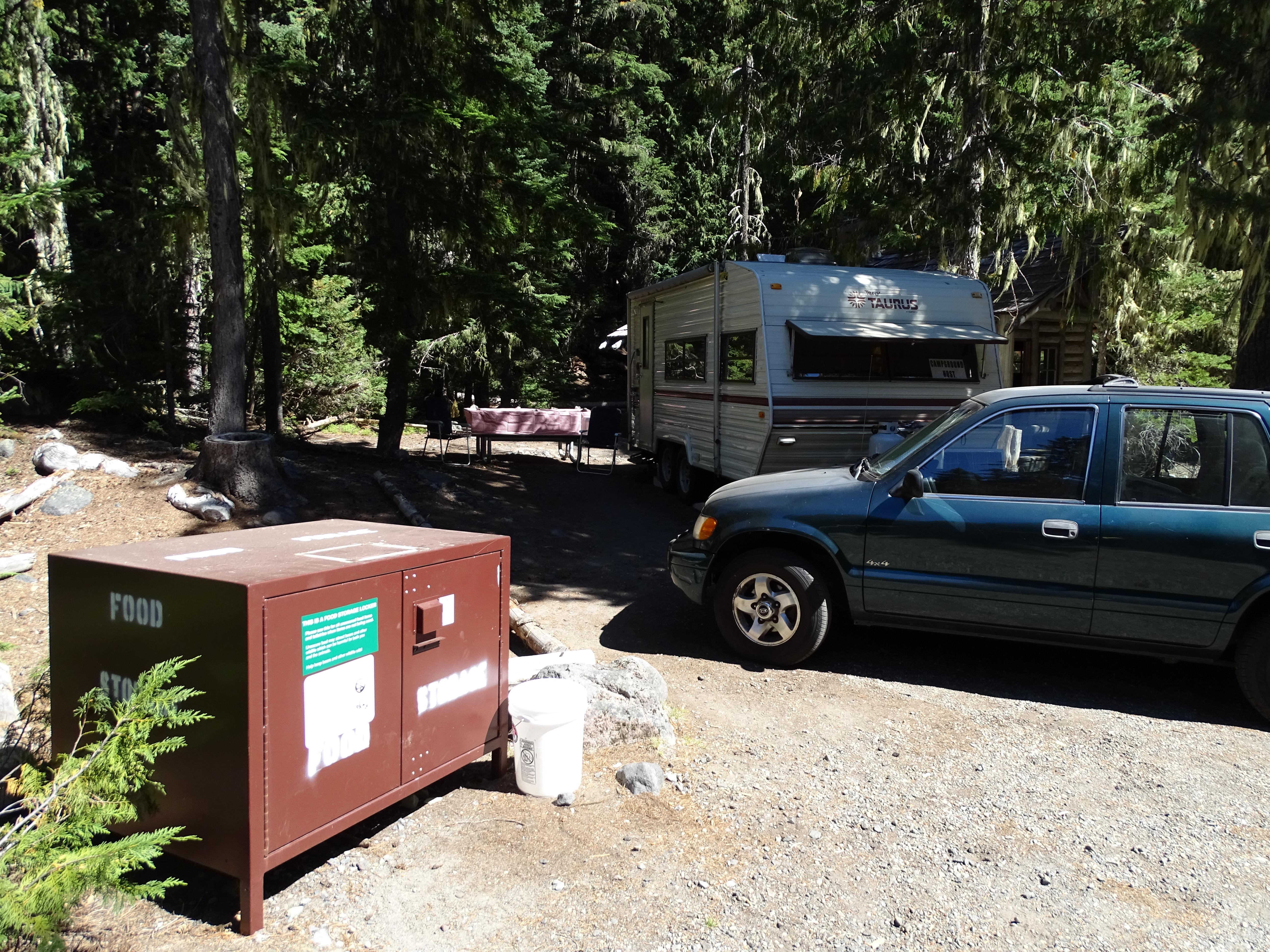 A brown metal container infront of an RV campsite