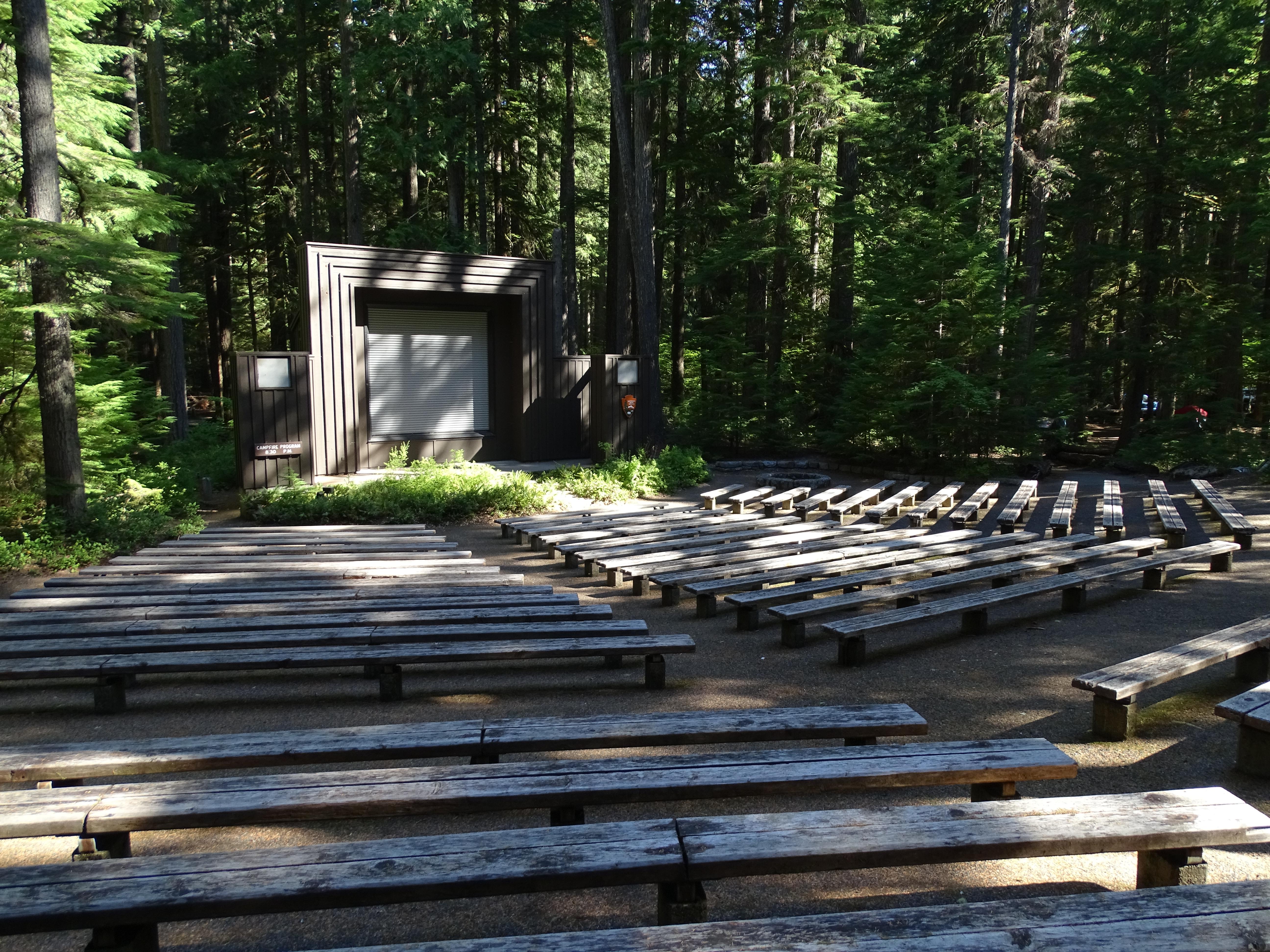 Rows of wooden benches leading up to a large projection screen.