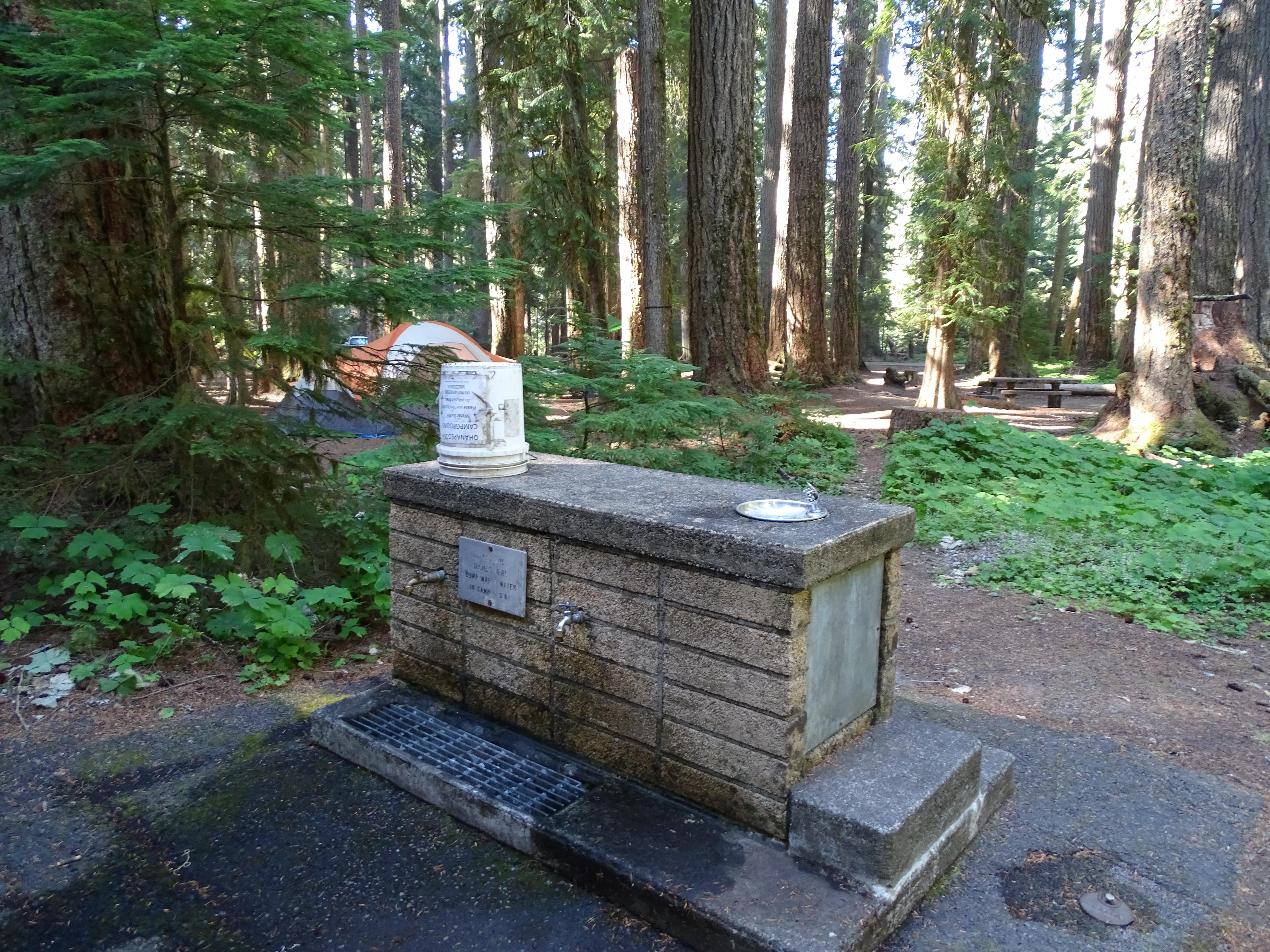 A small stone structure with faucets for getting water.