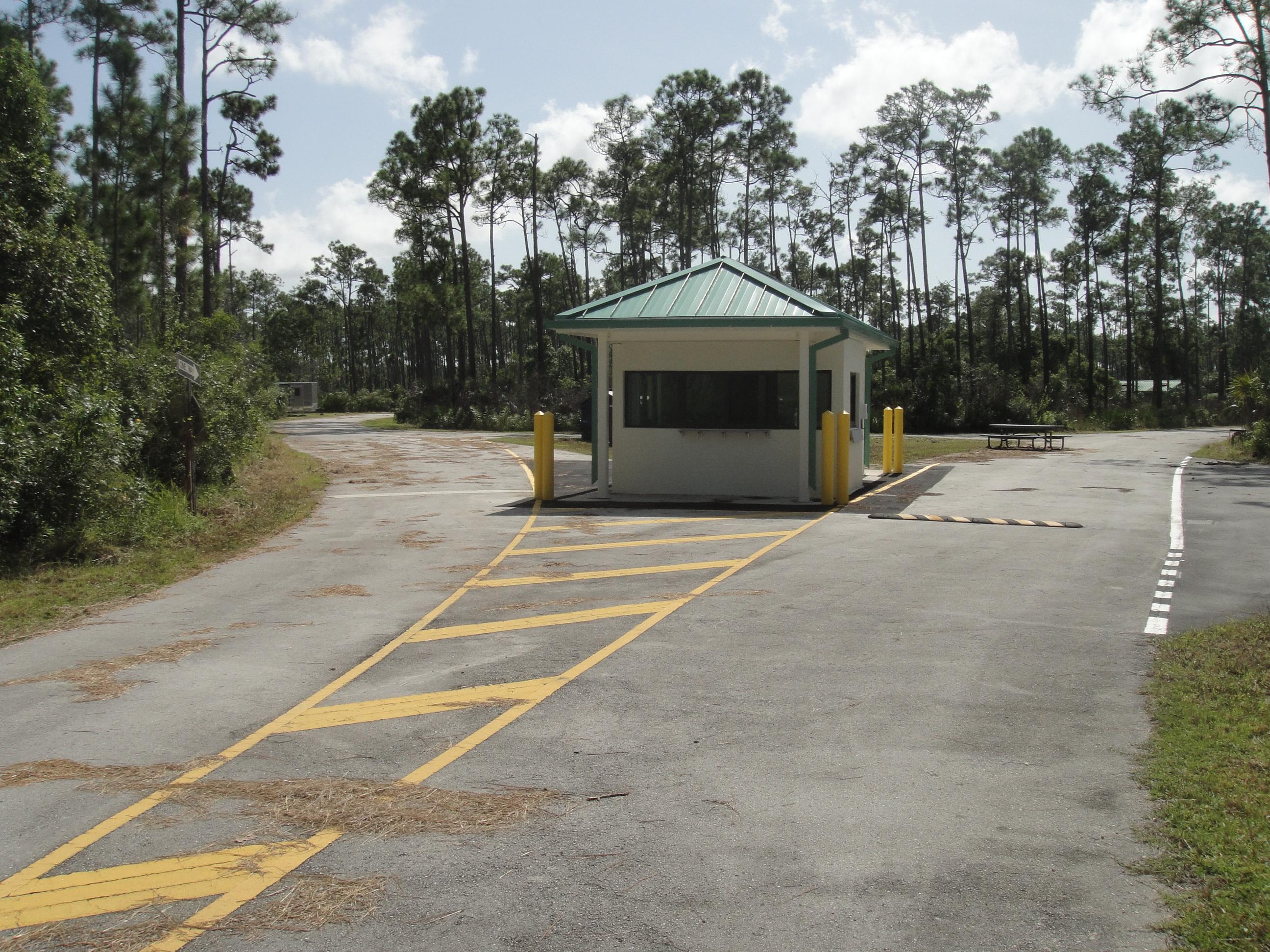 A white fees building with green roof welcomes campers
