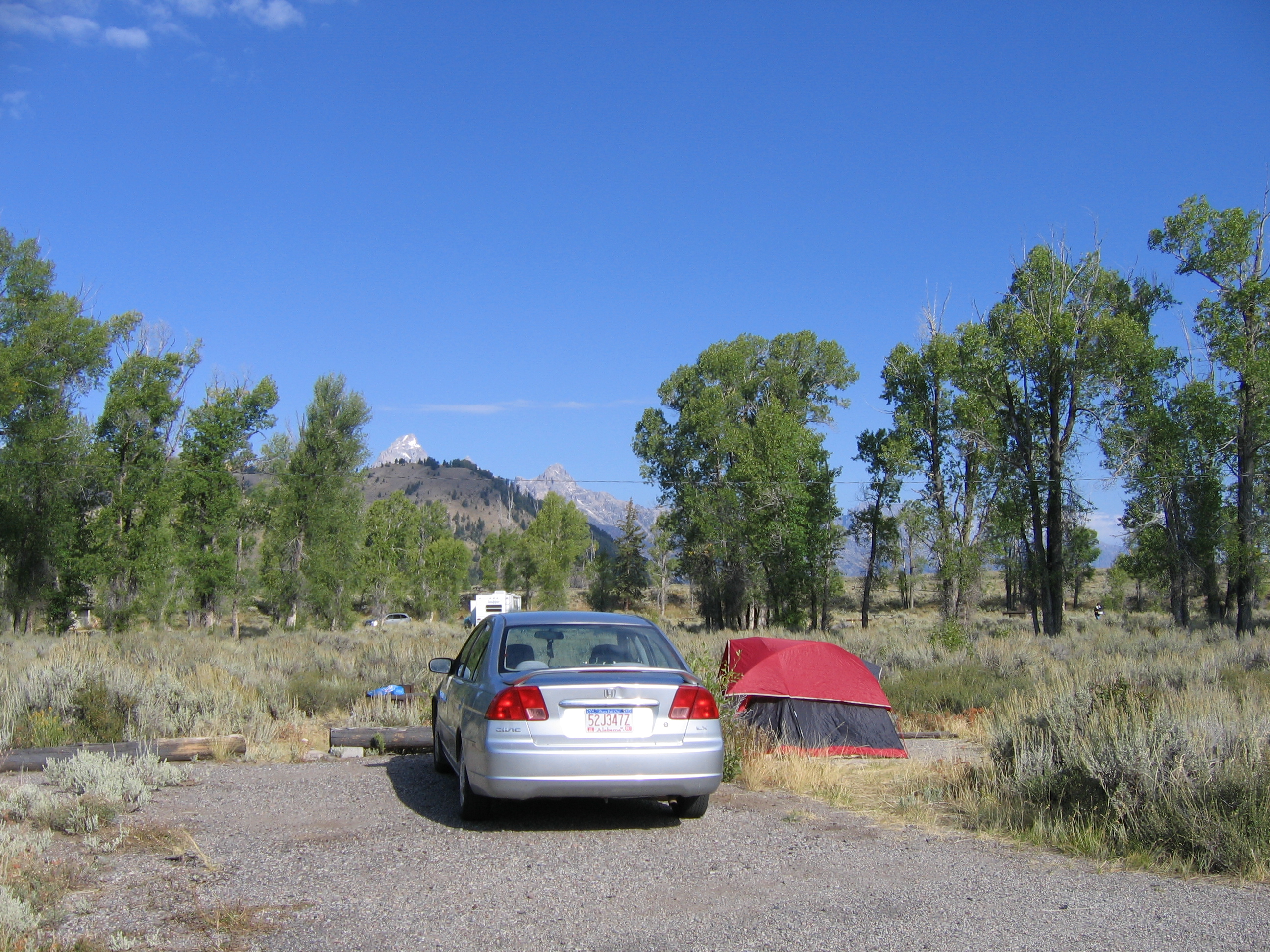 Gros Ventre campsite with red tent and silver sedan surrounded by sagebrush and cottonwoods