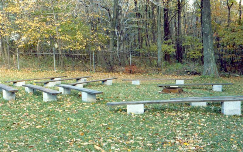 Wooden benches surrounding a metal fire ring