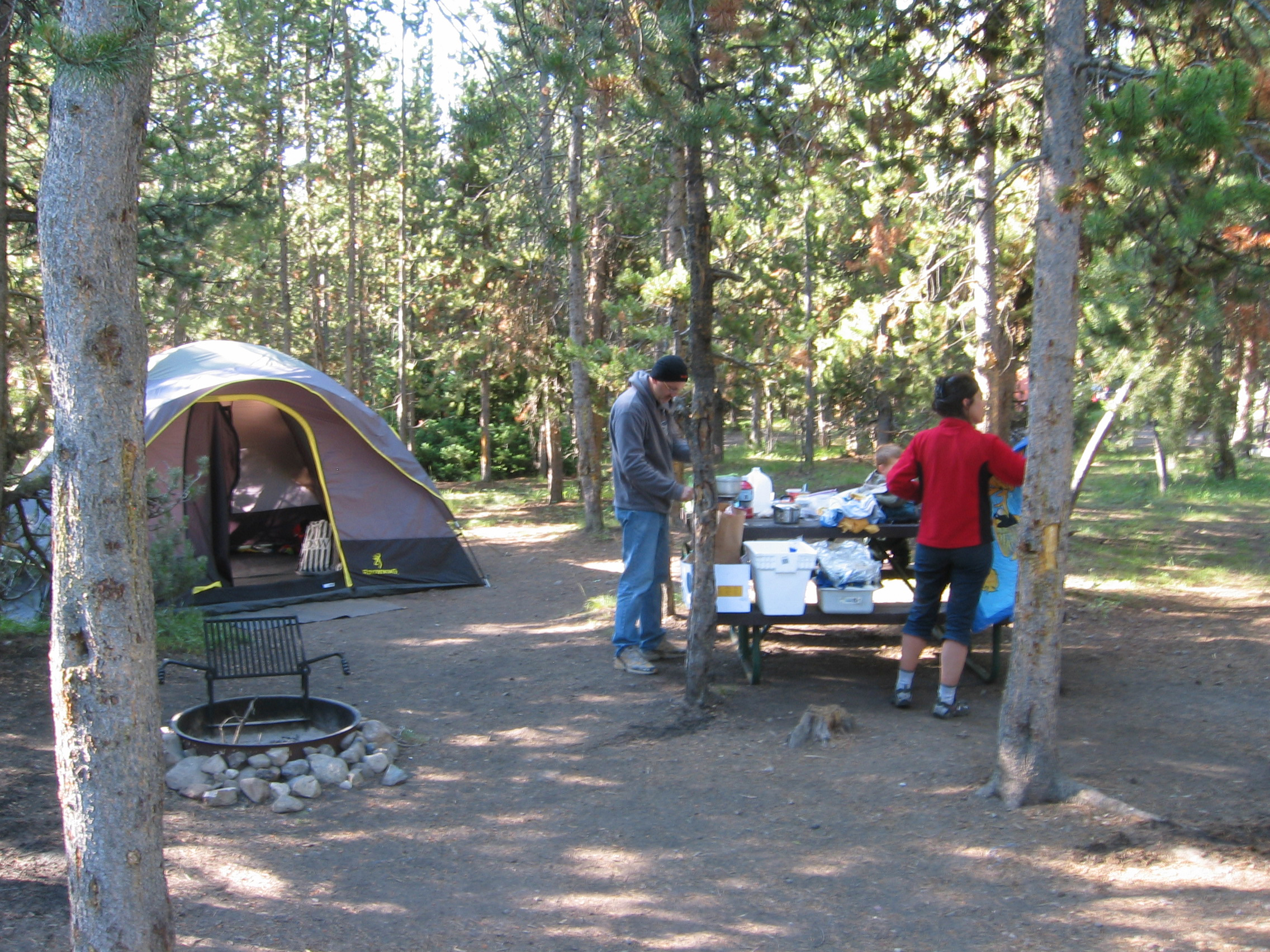 Tent at people at campsite.