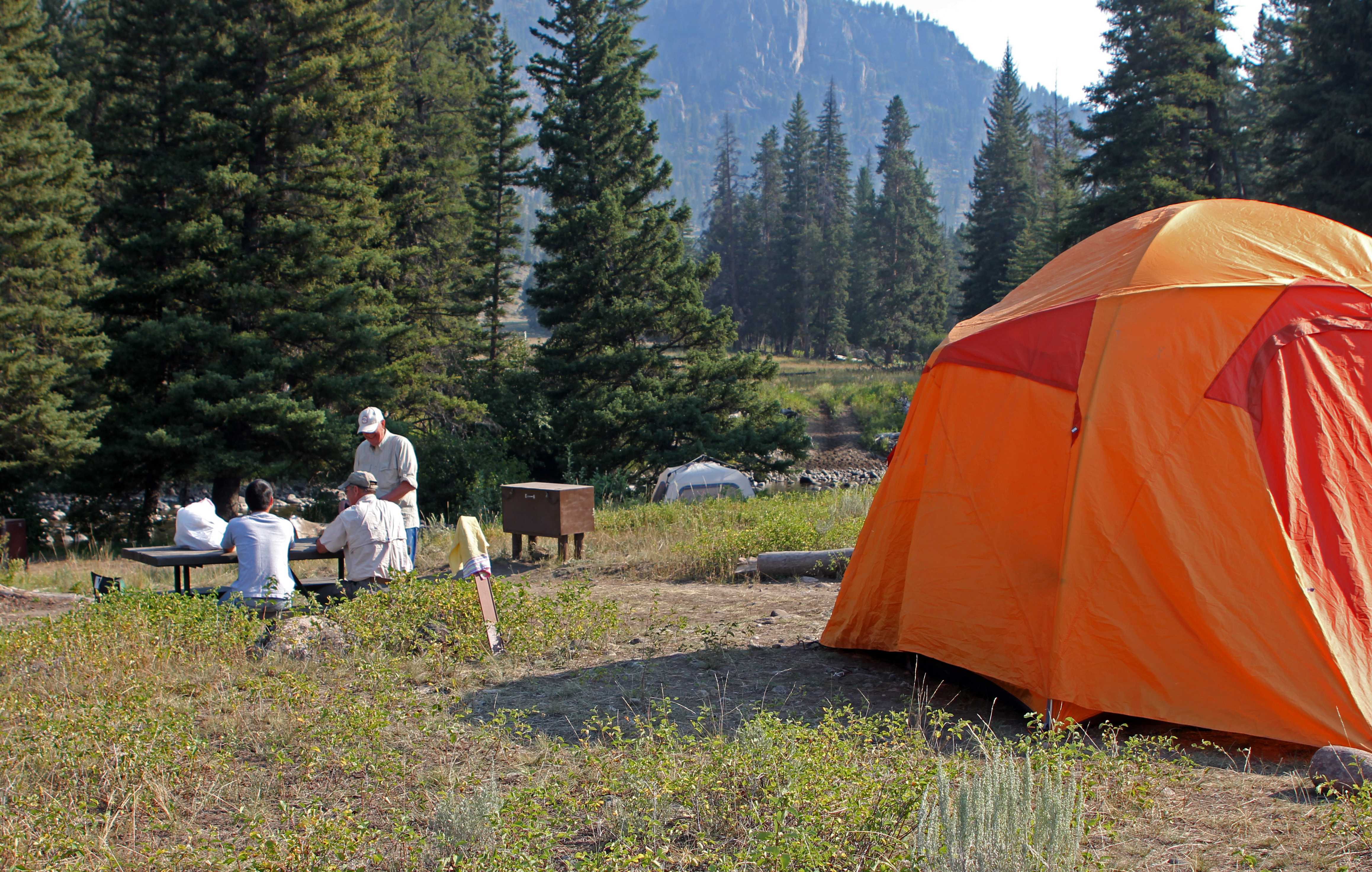 Visitors and tent at campsite.