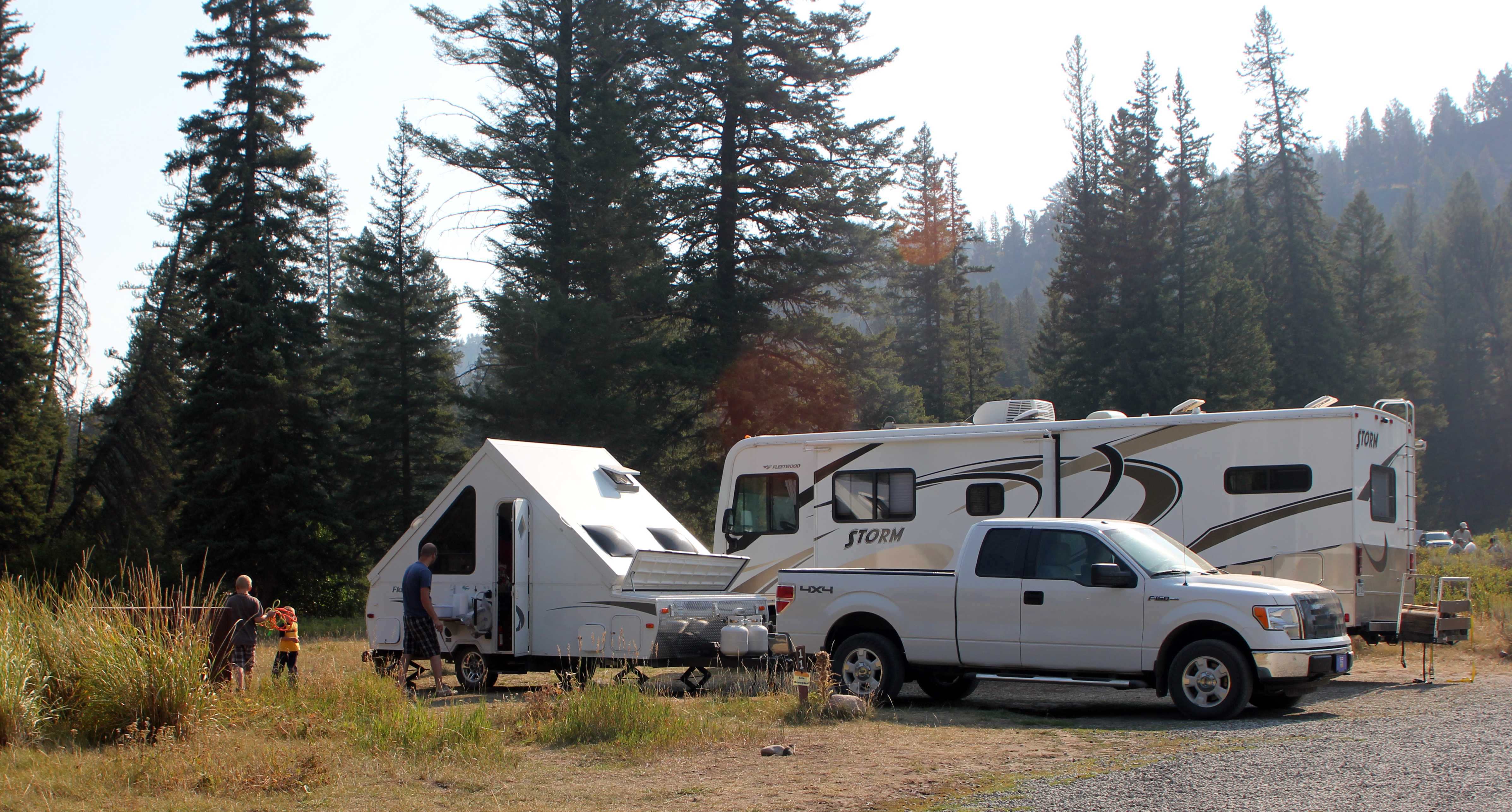 Truck with camping trailer, RV at campsite