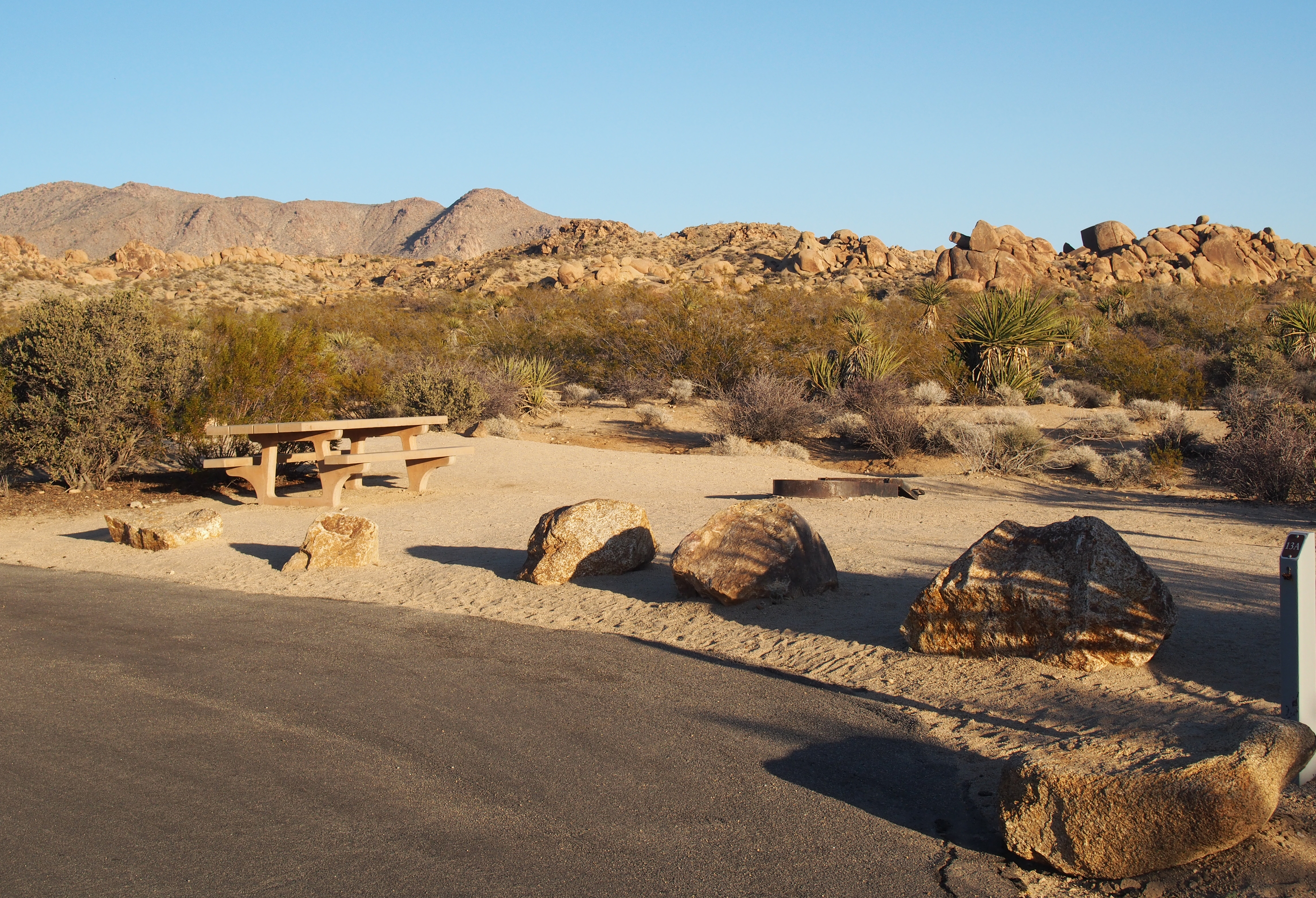 A campsite with a picnic table and fire pit.