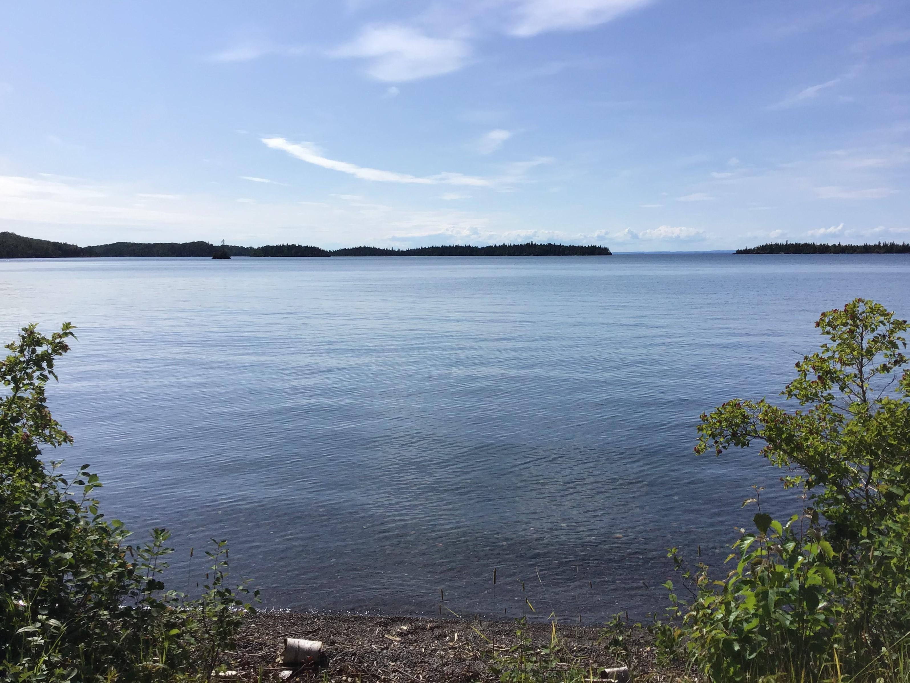 Shoreline of Todd Harbor, Lake Superior with blue sky and barrier islands.