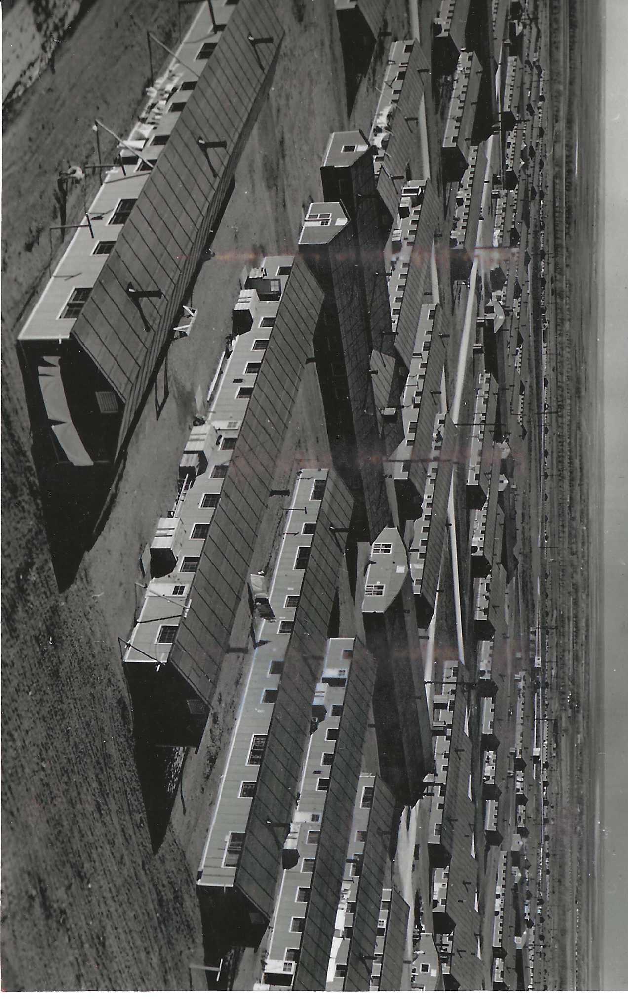 black and white image of rows of barracks from above.