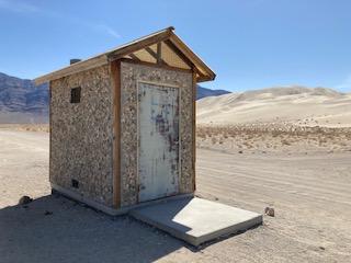 Vault toilet with sand dune in the background