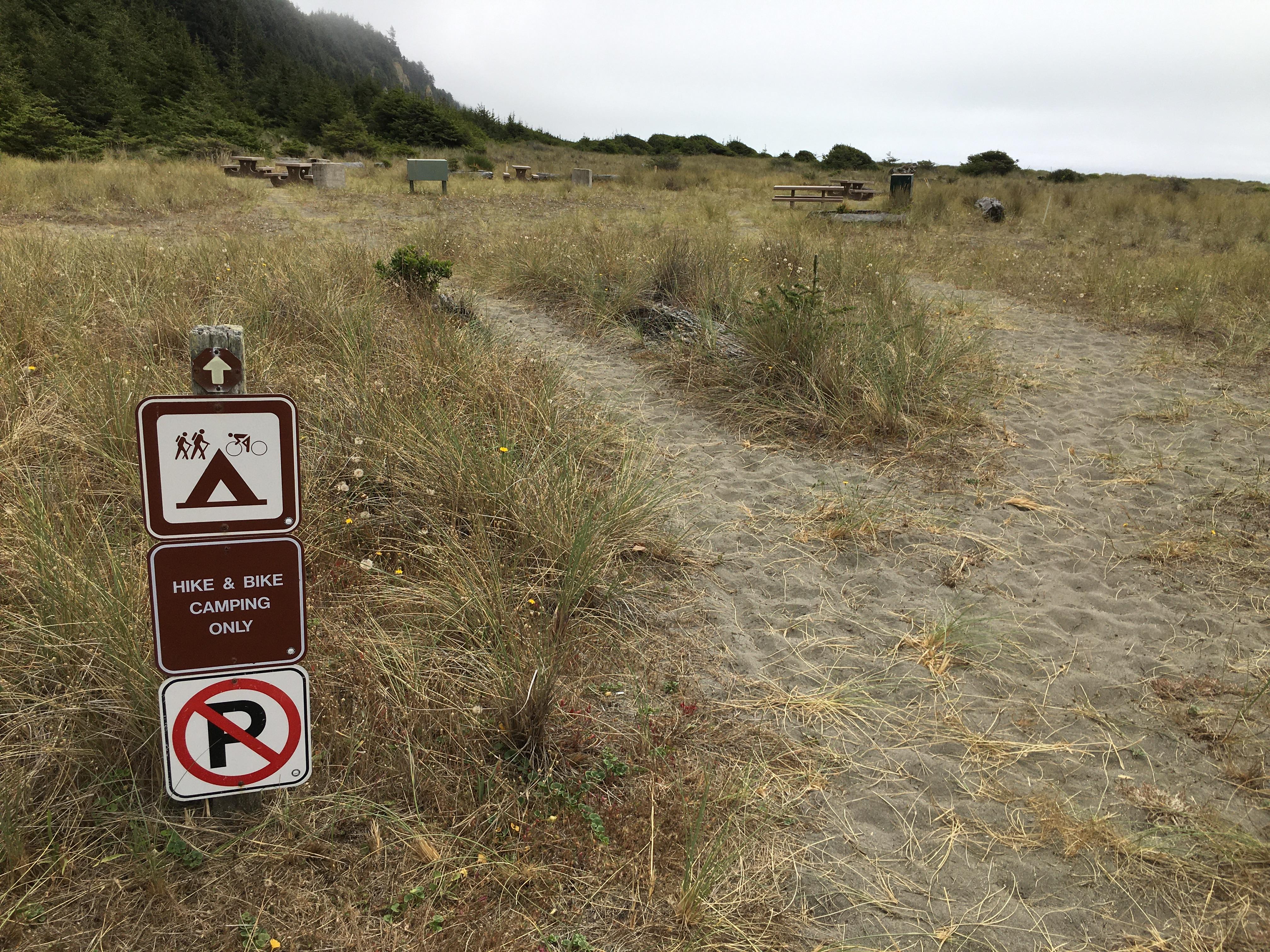 Sandy trail leads to a signed "hike and bike" site.