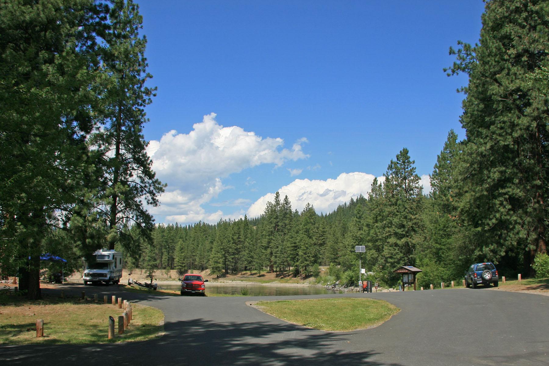 paved access road in the foreground leading to the boat launch and lake in the background