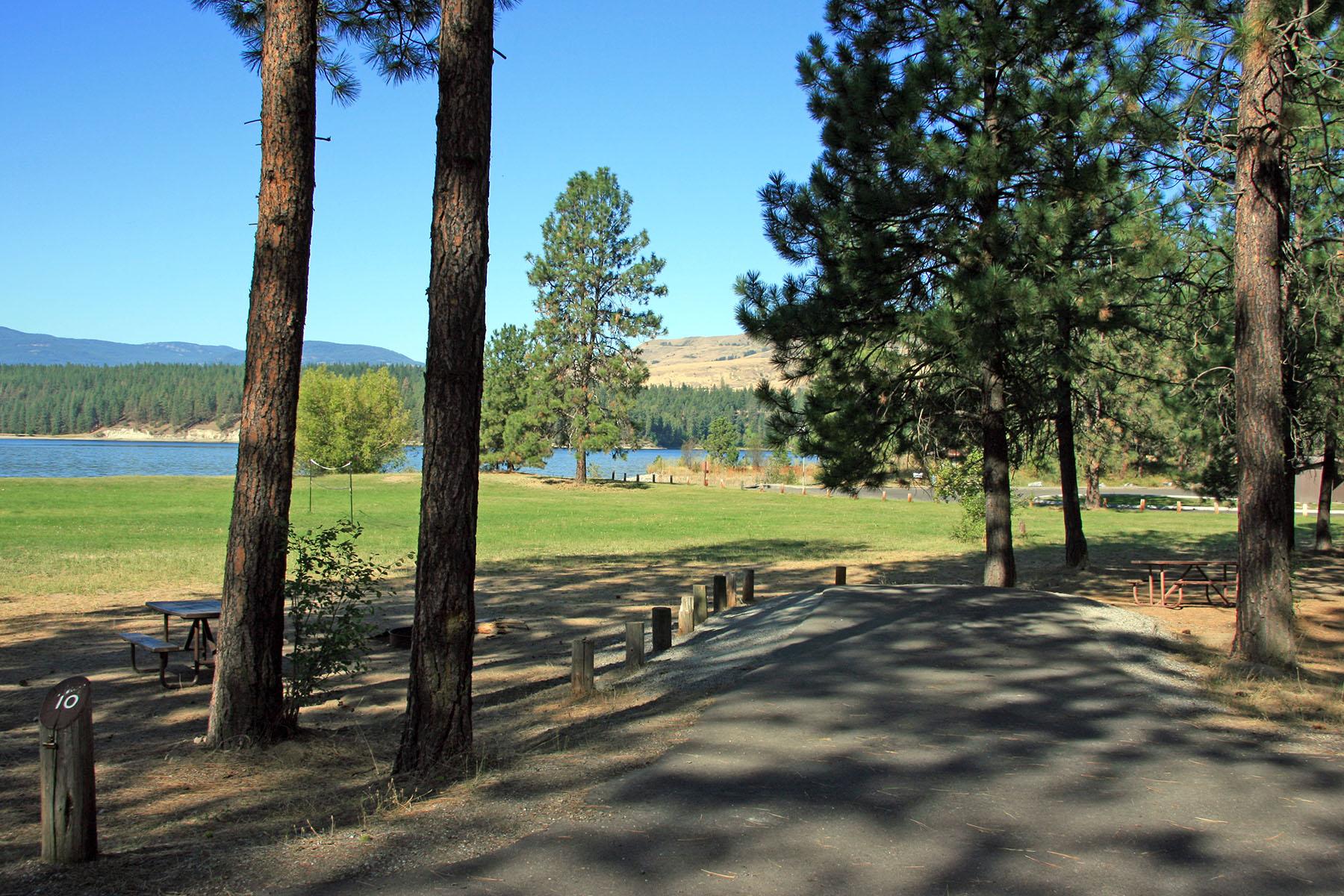 paved campsite parking area with lake in background