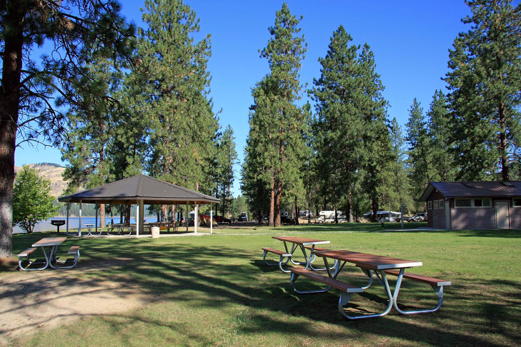 picnic tables in foreground, covered picnic area in background