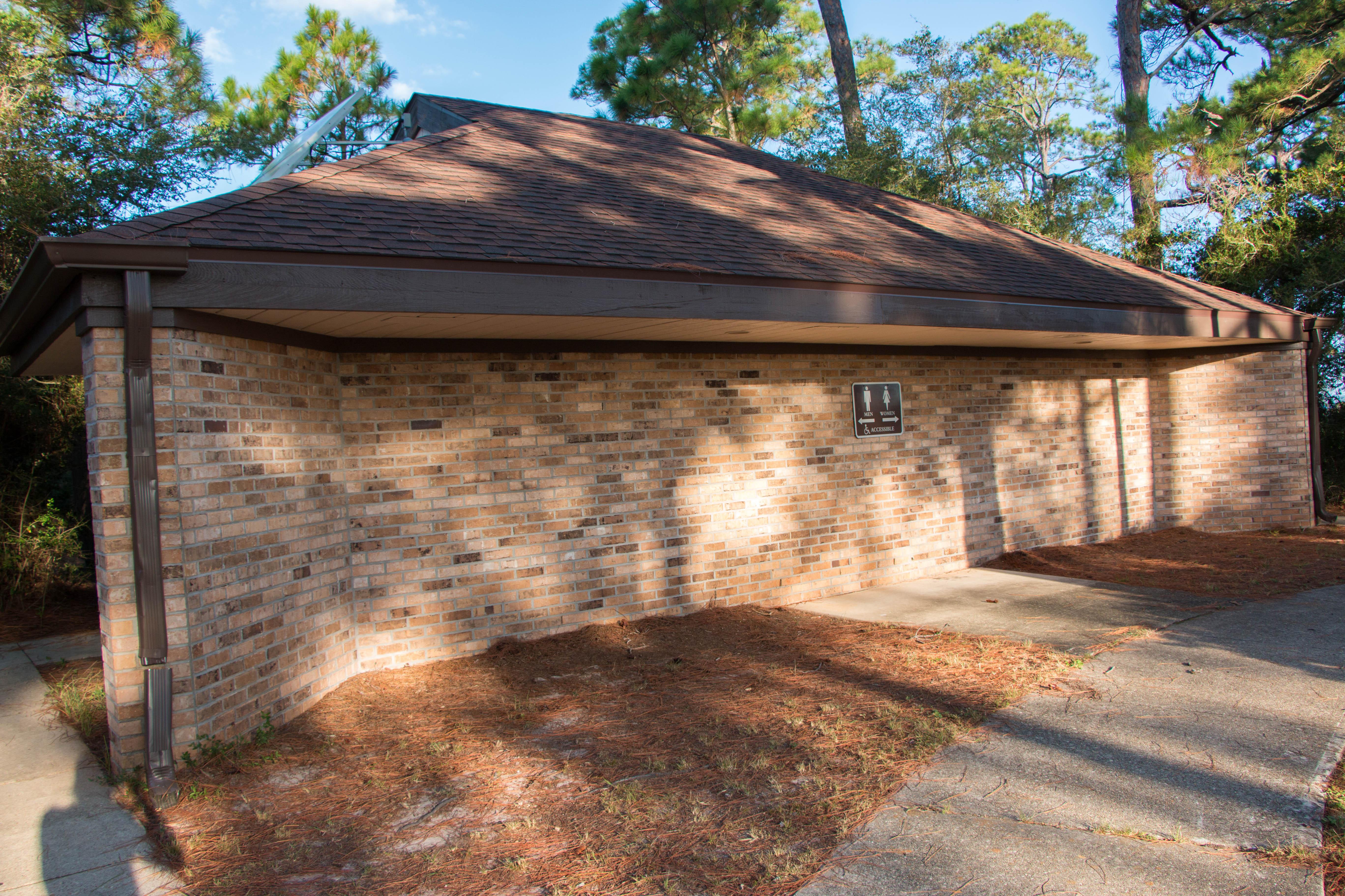 A brick building with restrooms on either side.