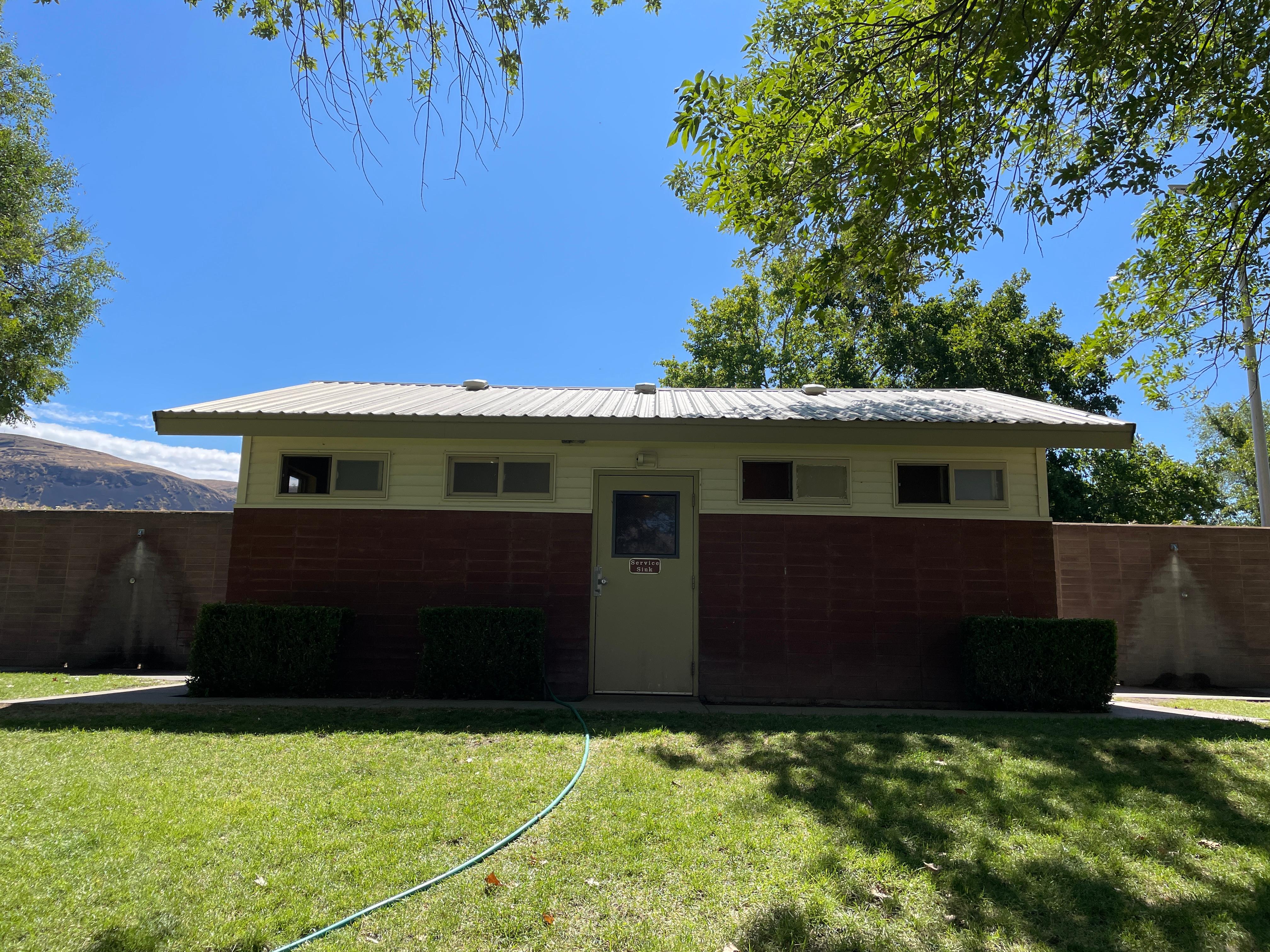 Brown and white building with restrooms on either side.