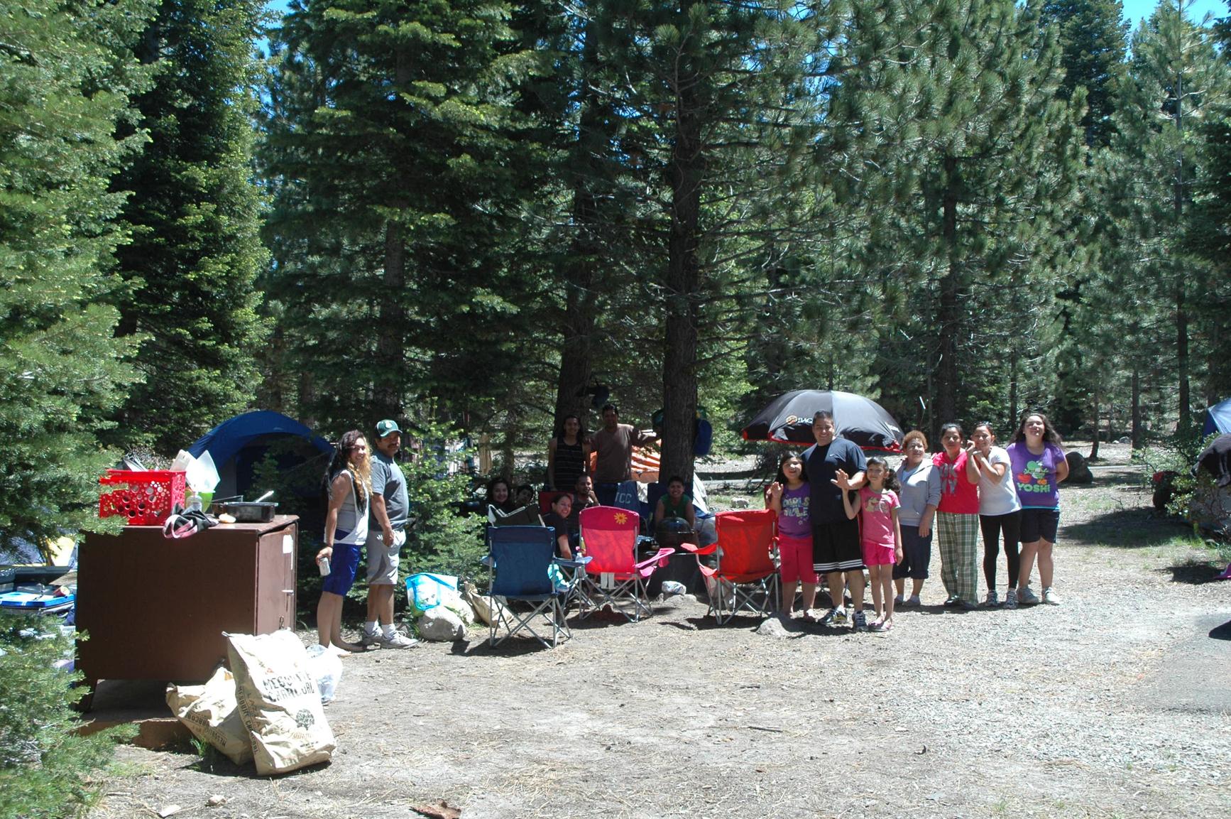 A large group of people pose for a photo at a campsite.