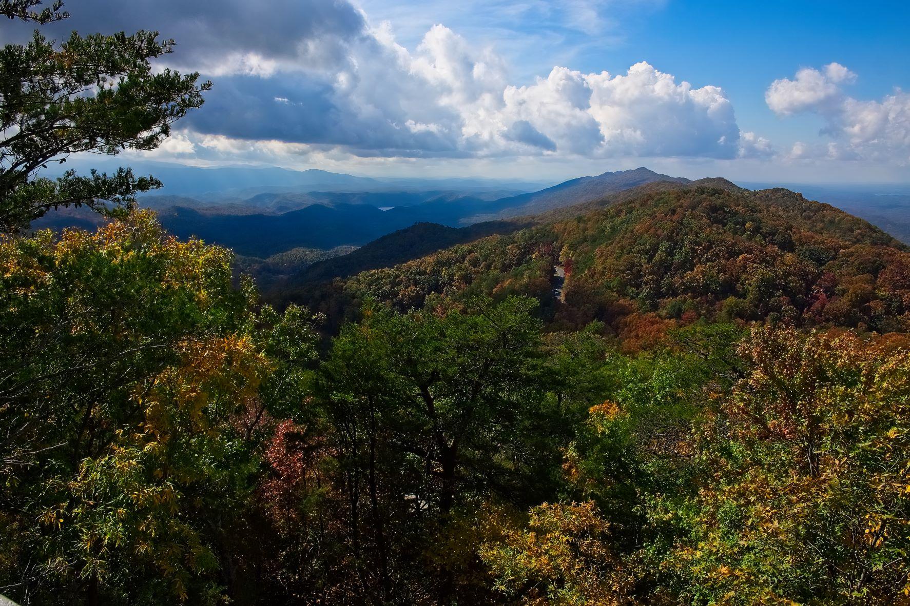 Early fall views of rolling mountains. A road cuts through the mountains touched with fall color.