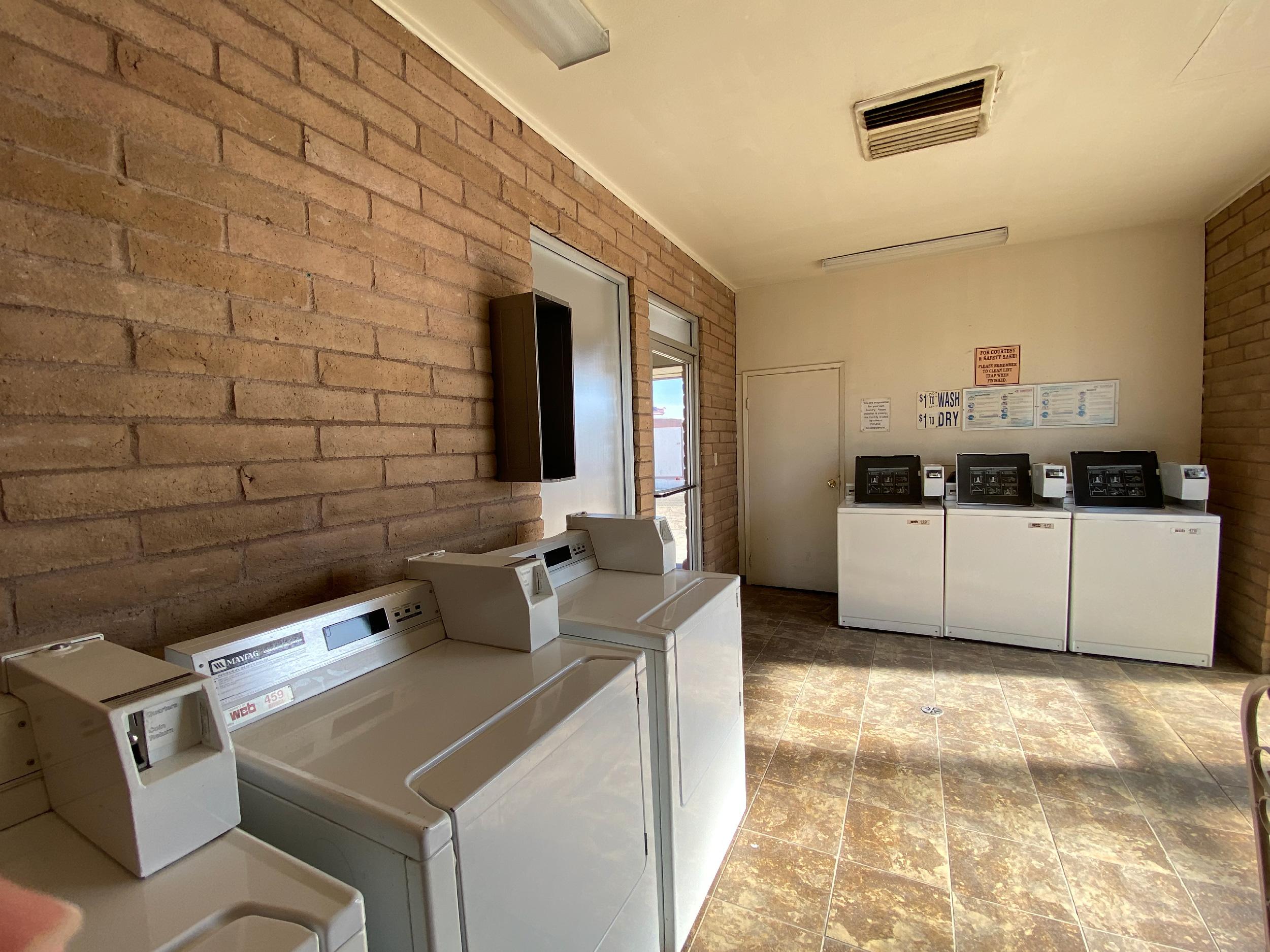 A set of washers and dryers inside a laundry facility