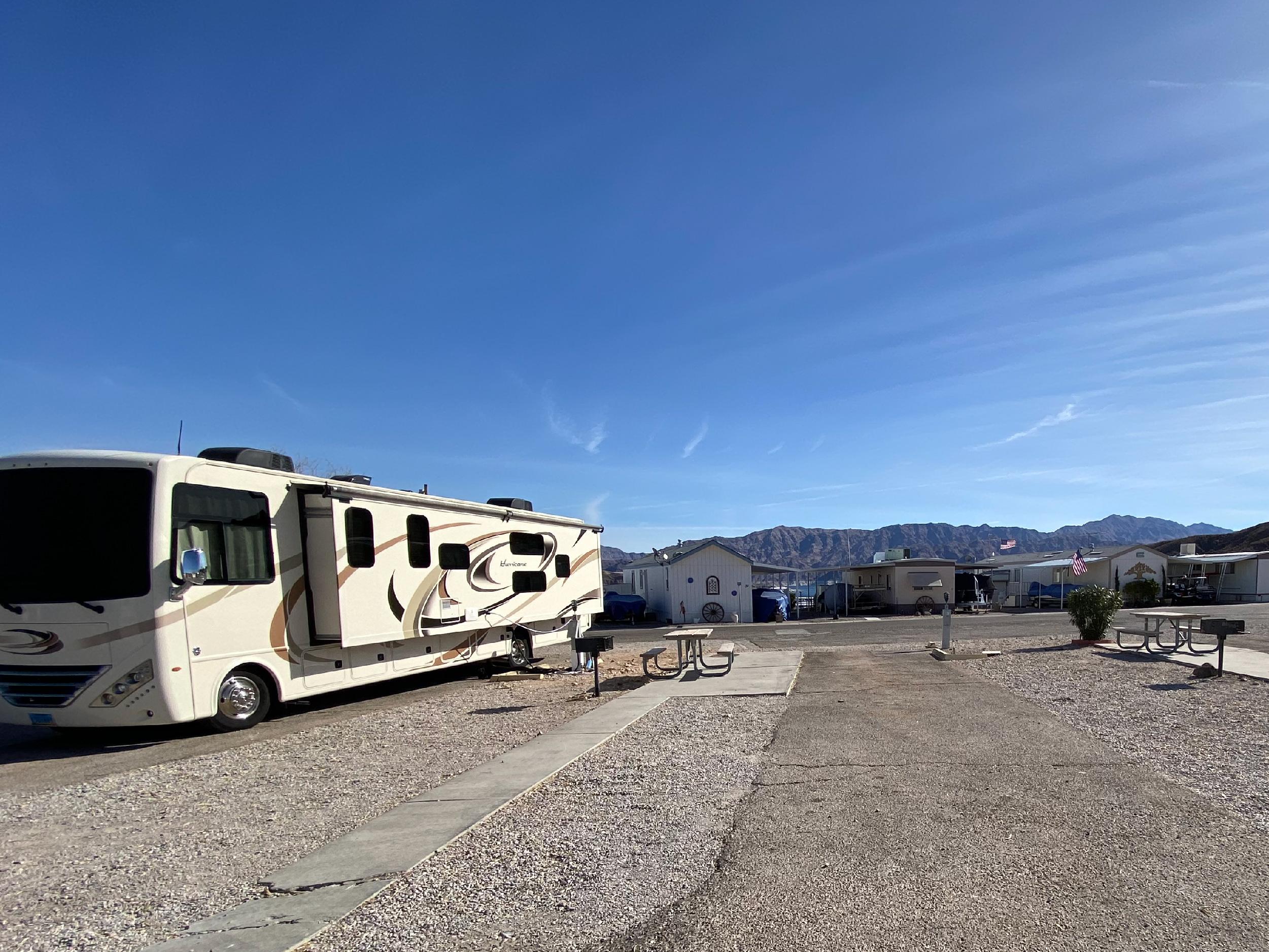 A RV sits parked in an open RV lot