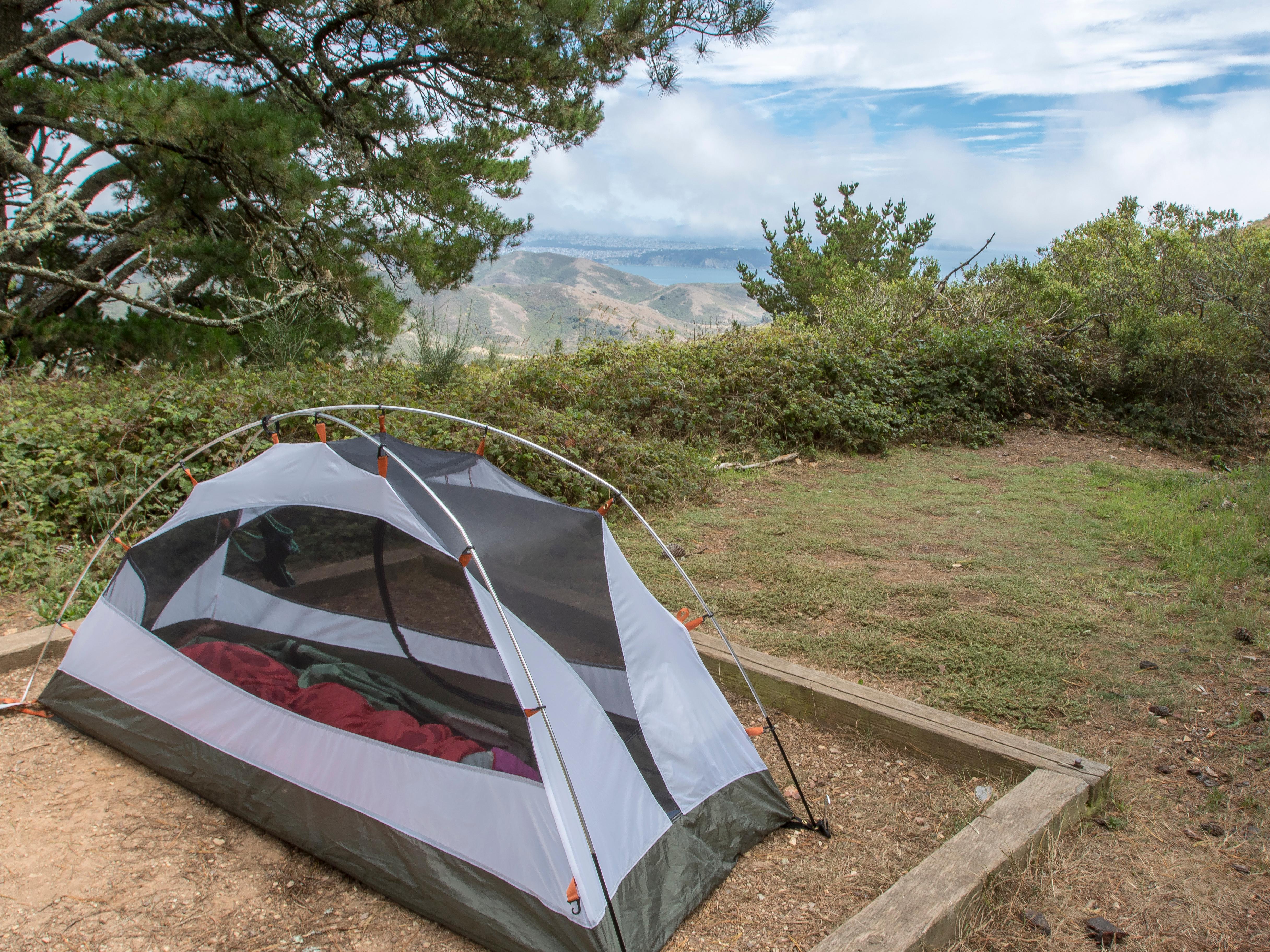 A gray and white single-person tent pitched at a campsite at Hawk Camp.