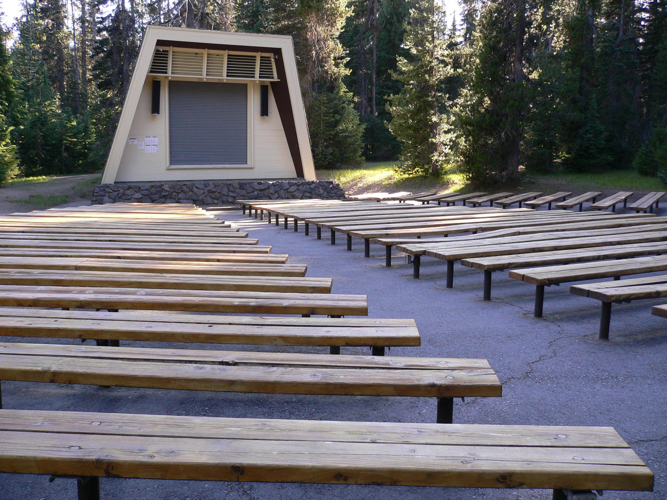 long benches with a center walk face a raised amphitheater structure with screen