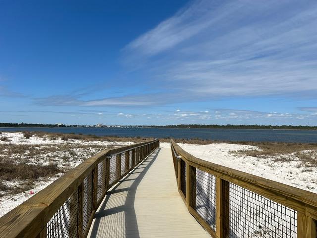 Wood boardwalk to a sound water.