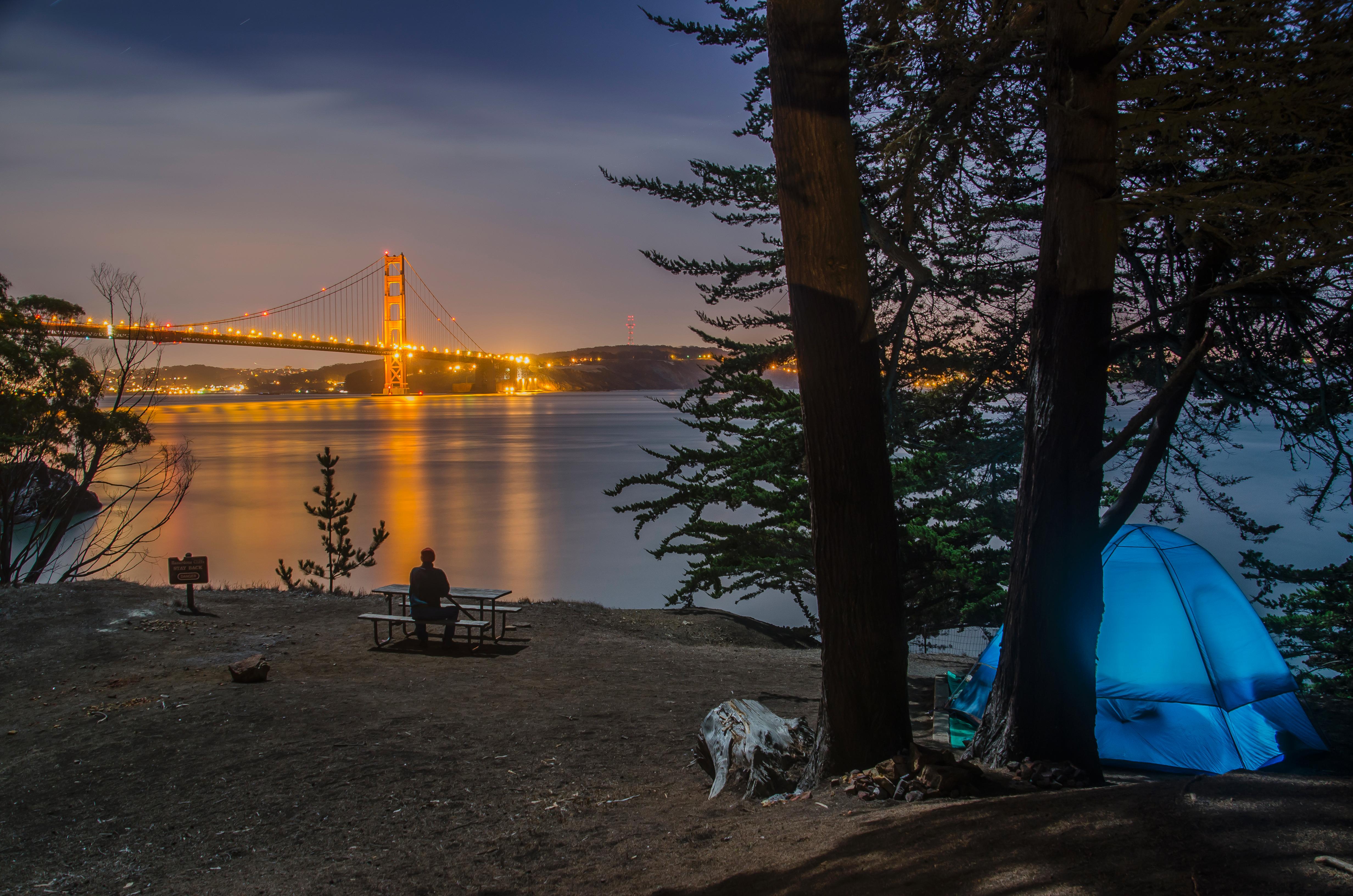 A colorful display of the Golden Gate Bridge lit up against the purple and blue night sky.