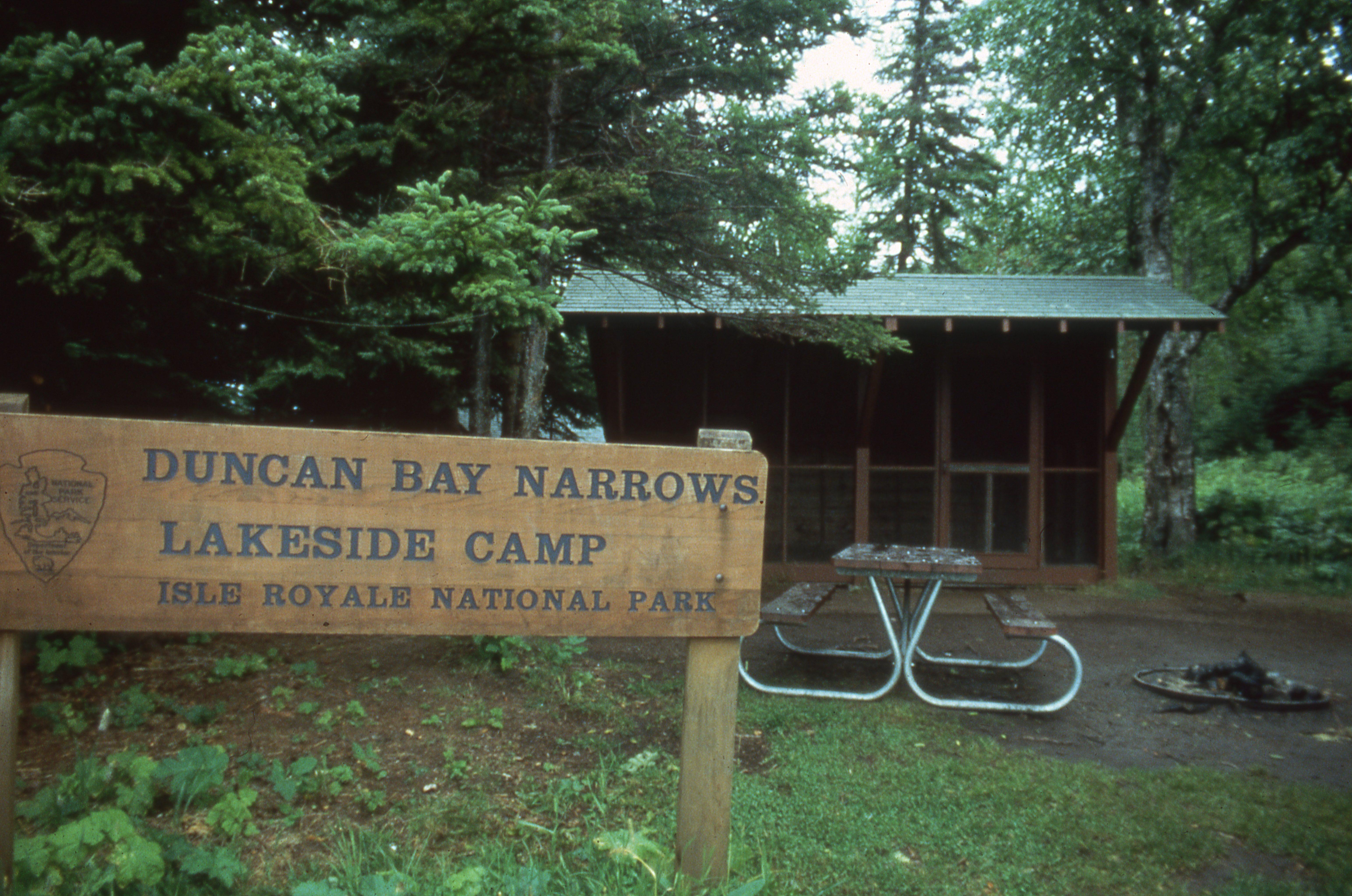 Campground Sign with picnic table and shelter in the background