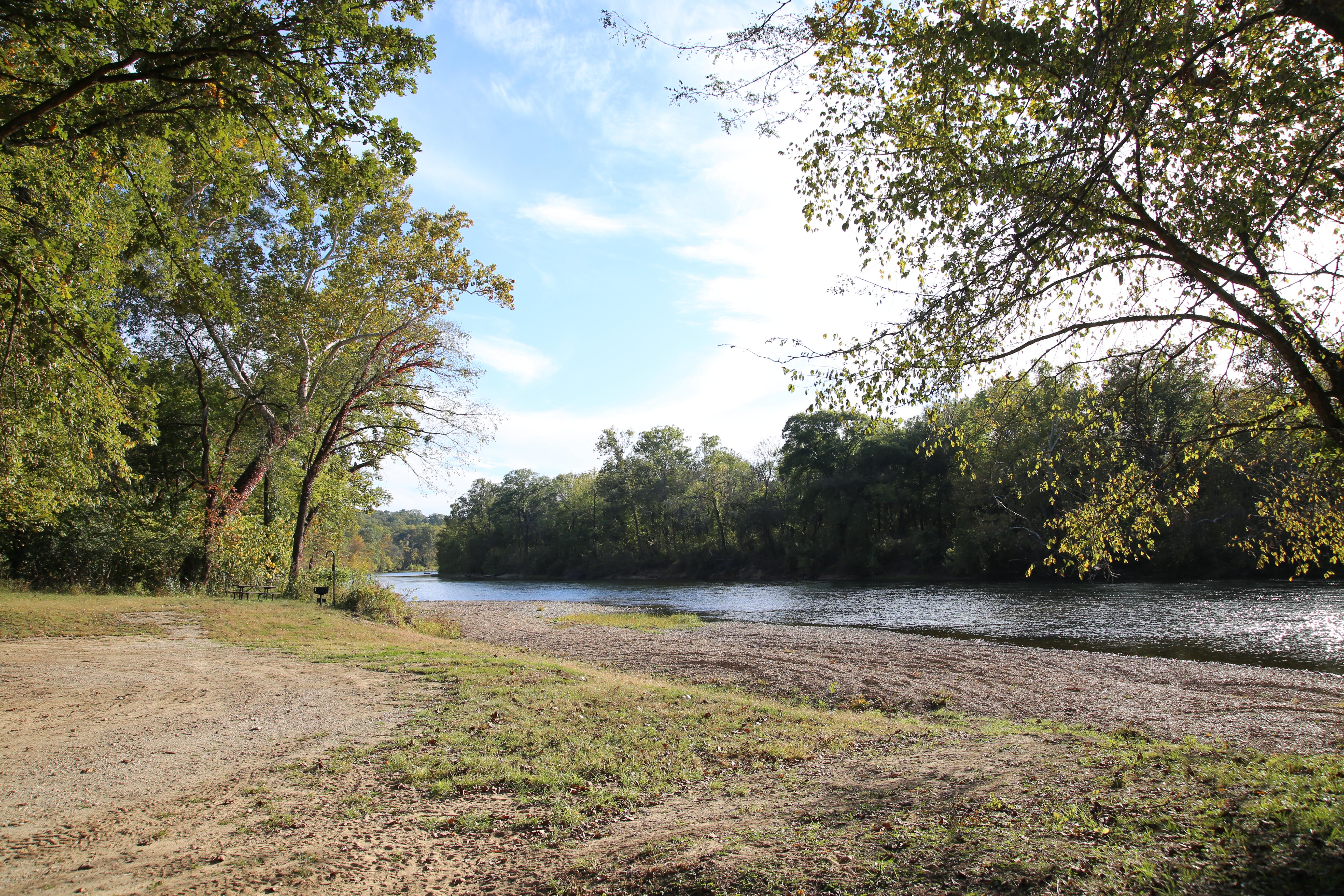 A grassy campsite is only yards away from the river's edge.