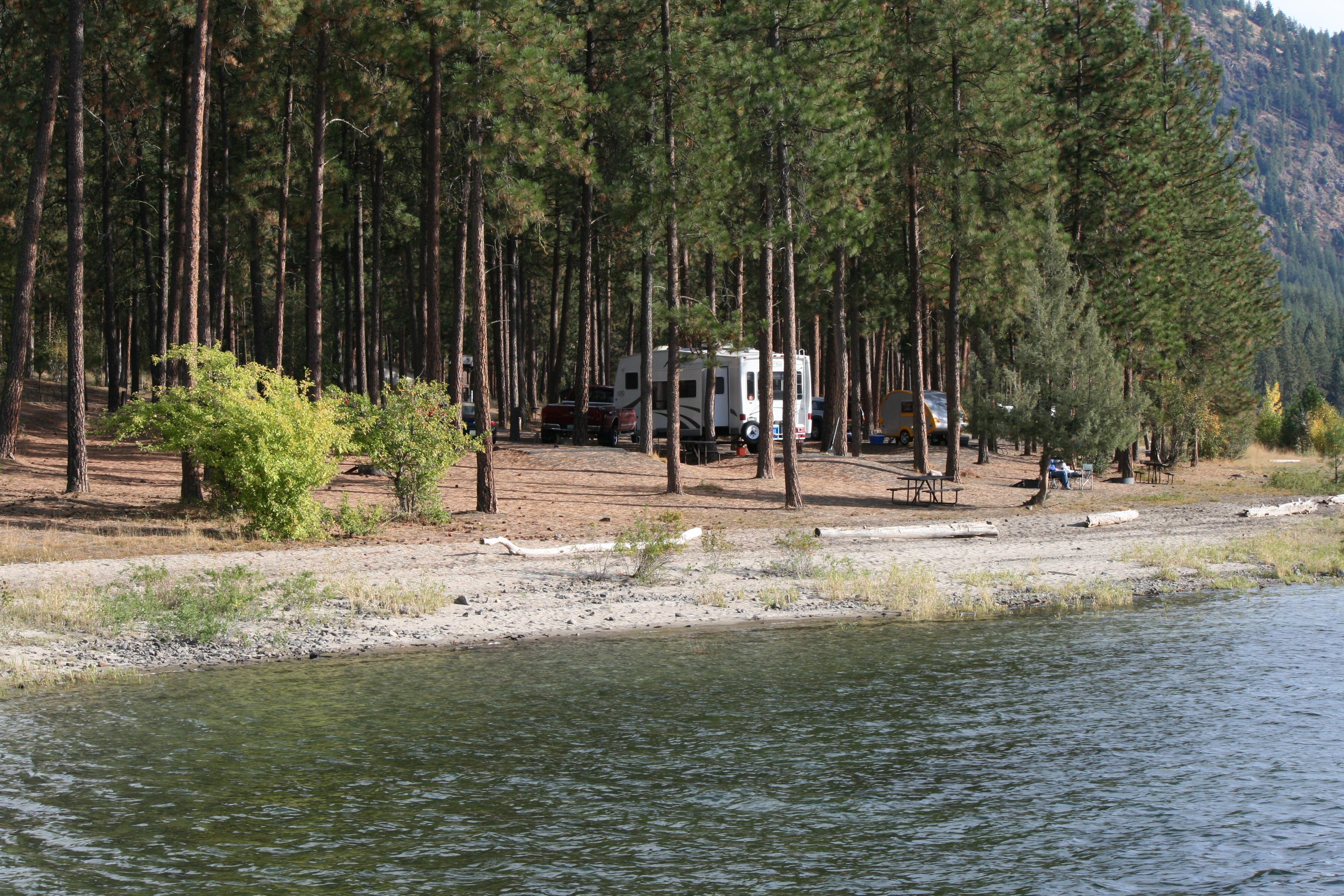 View across a small inlet to several campsites in the pines.