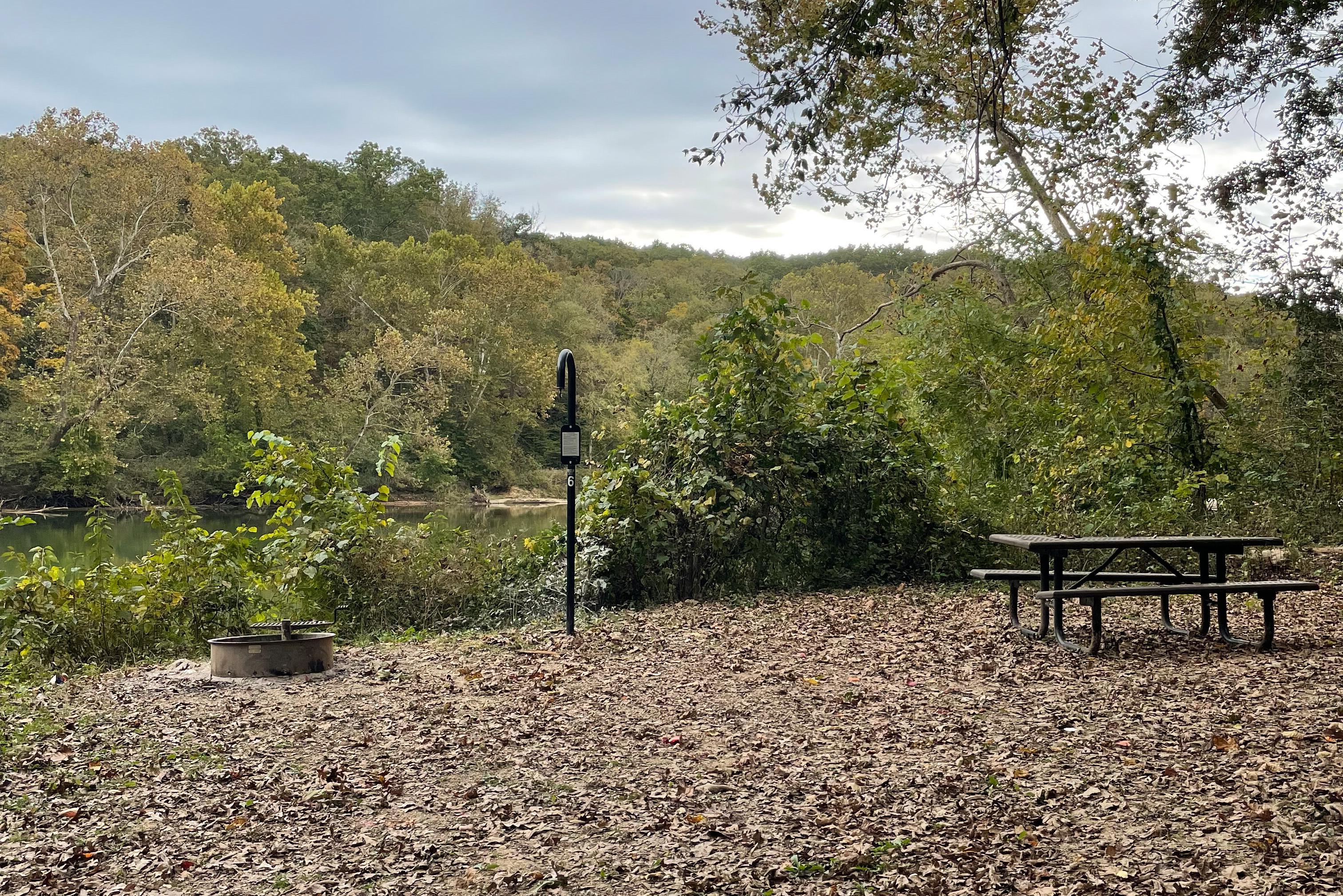 A campsite separated from the river by brush.