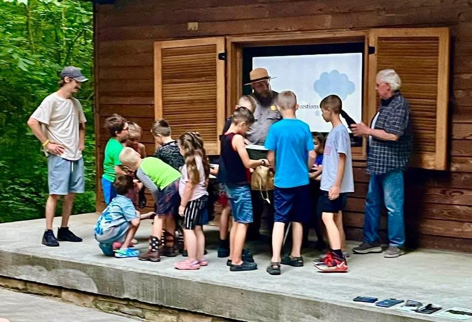 A group of visitors standing around a park ranger in discussion.