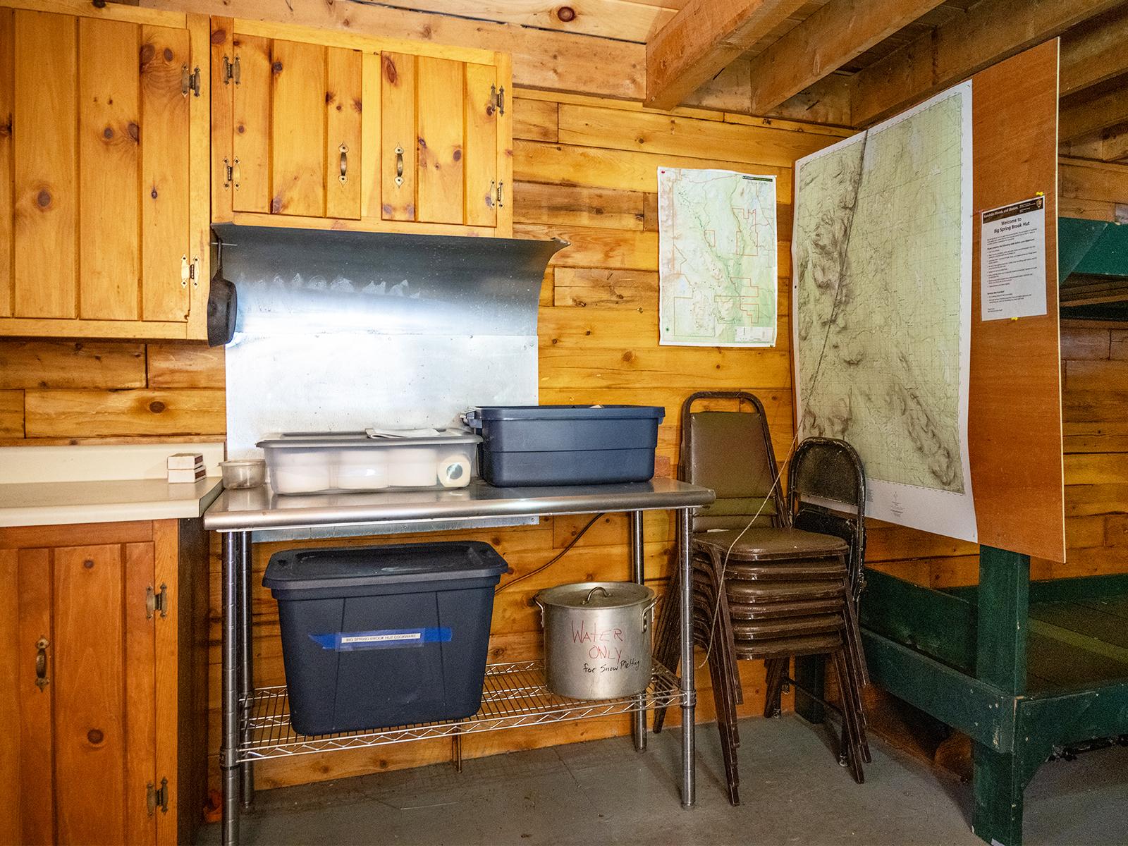Plastic tubs and a silver pot on a silver industrial kitchen table sit ready for visitors to use.