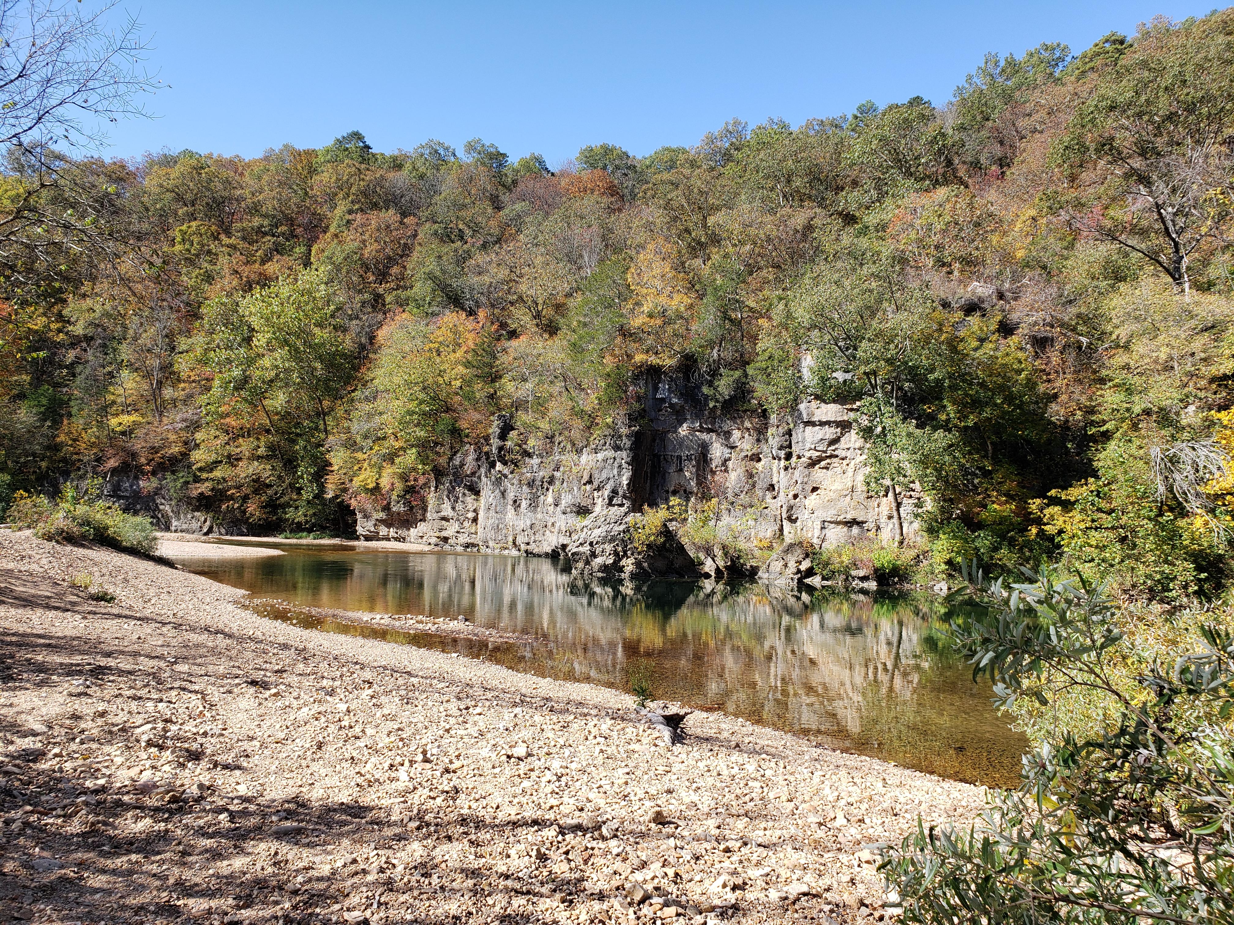 Boulders and bluffs are partially submerged by a river.